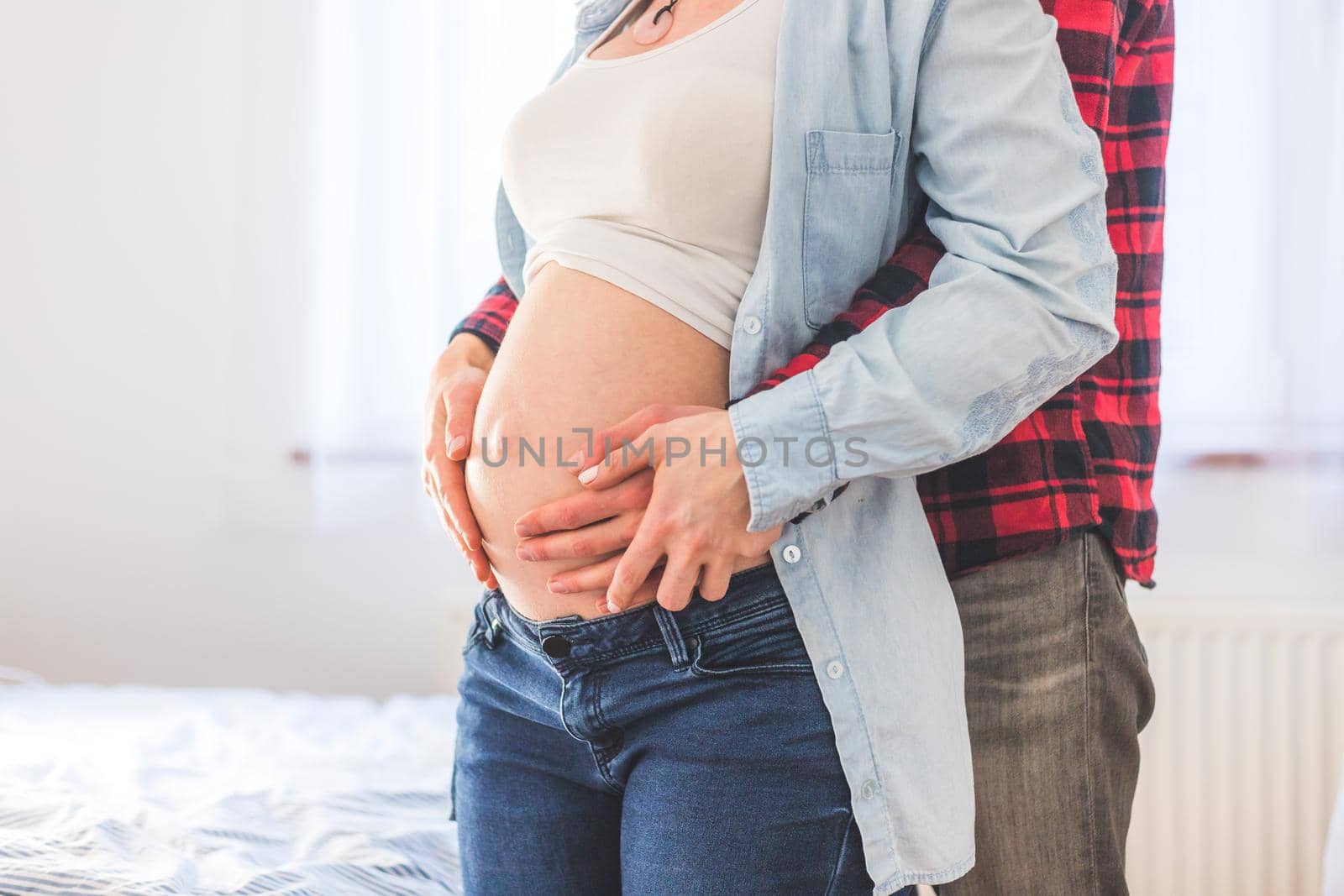 Close up of pregnant mother and father, hugging the tummy, Caucasian