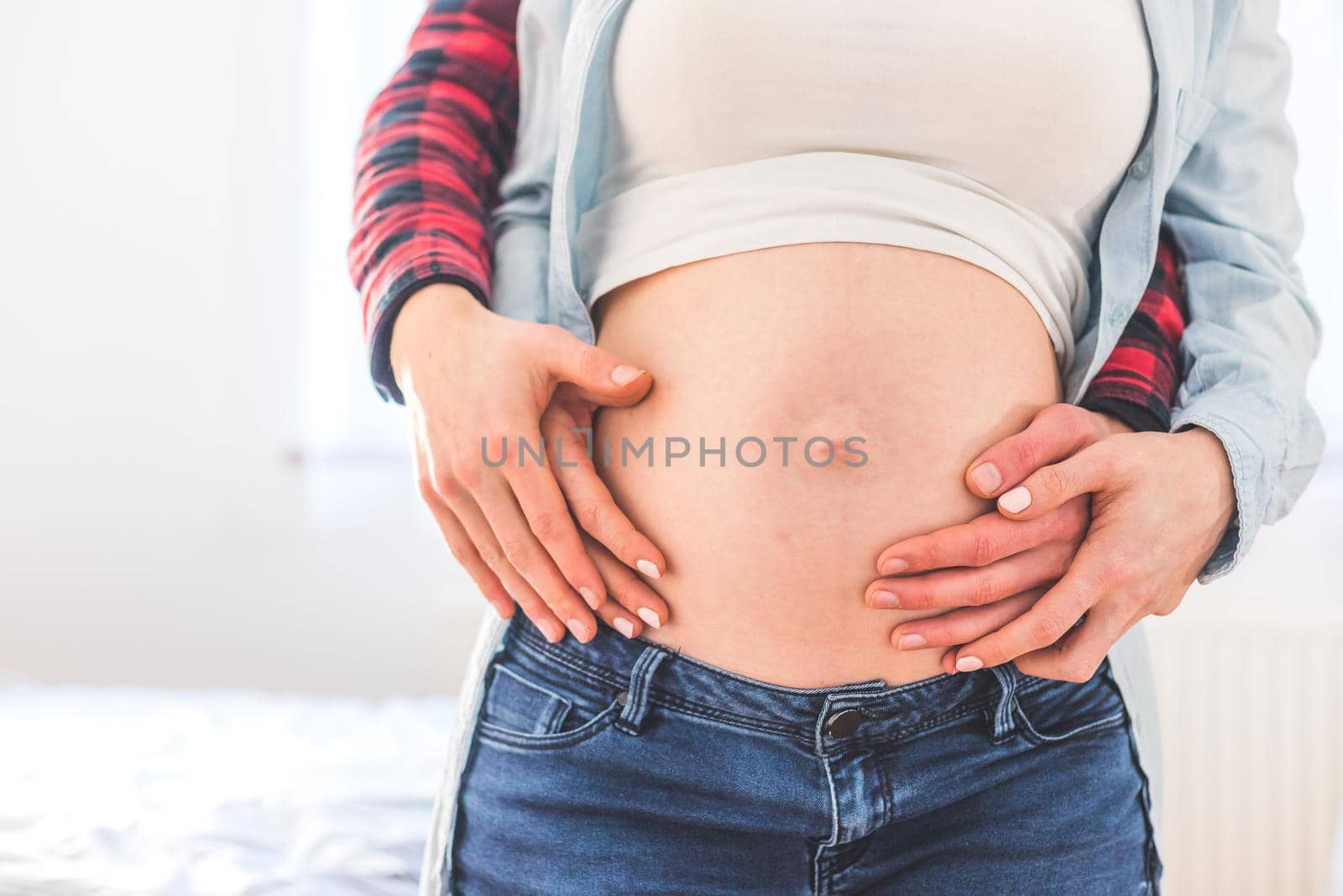 Close up of pregnant mother and father, hugging the tummy, Caucasian