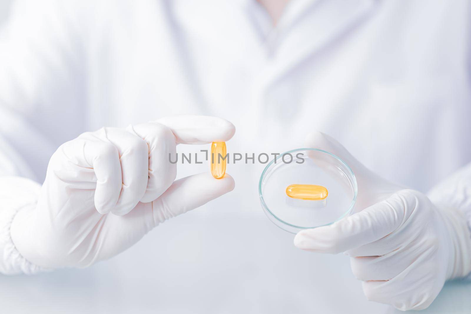 Close up Scientist hands putting in nitrile latex gloves holding Scientist holding capsule gel in labcoat wearing nitrile gloves, doing experiments in lab