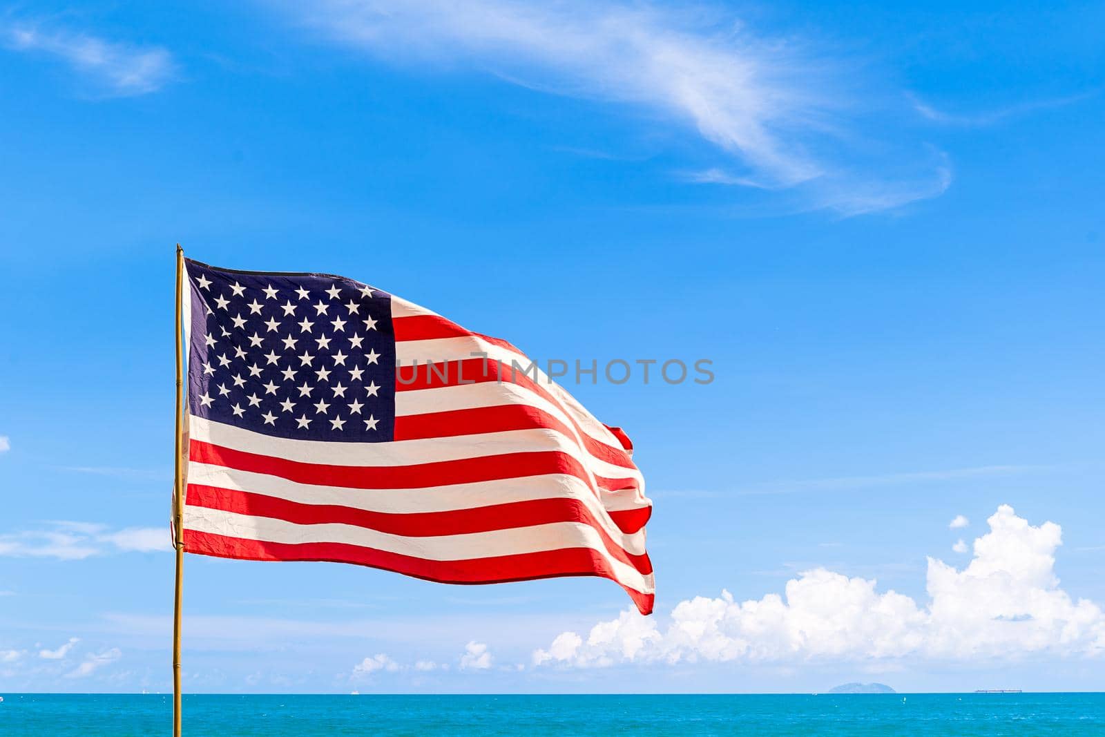 Flag of United States of America (USA) waving in the wind with blue sky and cloud on a sunny day