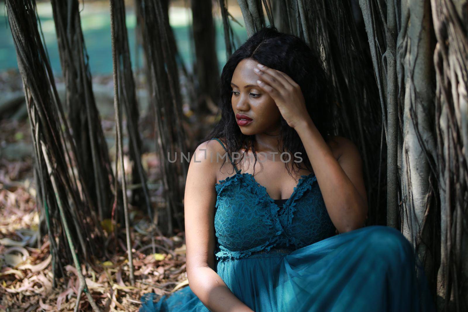 Cheerful young woman standing by tree in the jungle. 