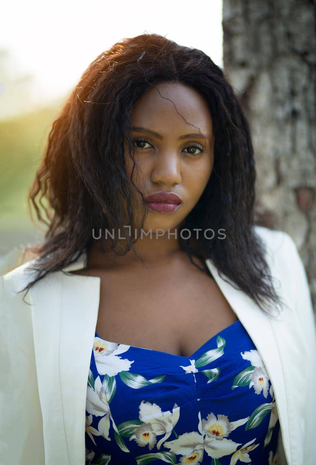 Cheerful young Afro American woman standing in tropical garden. by chuanchai