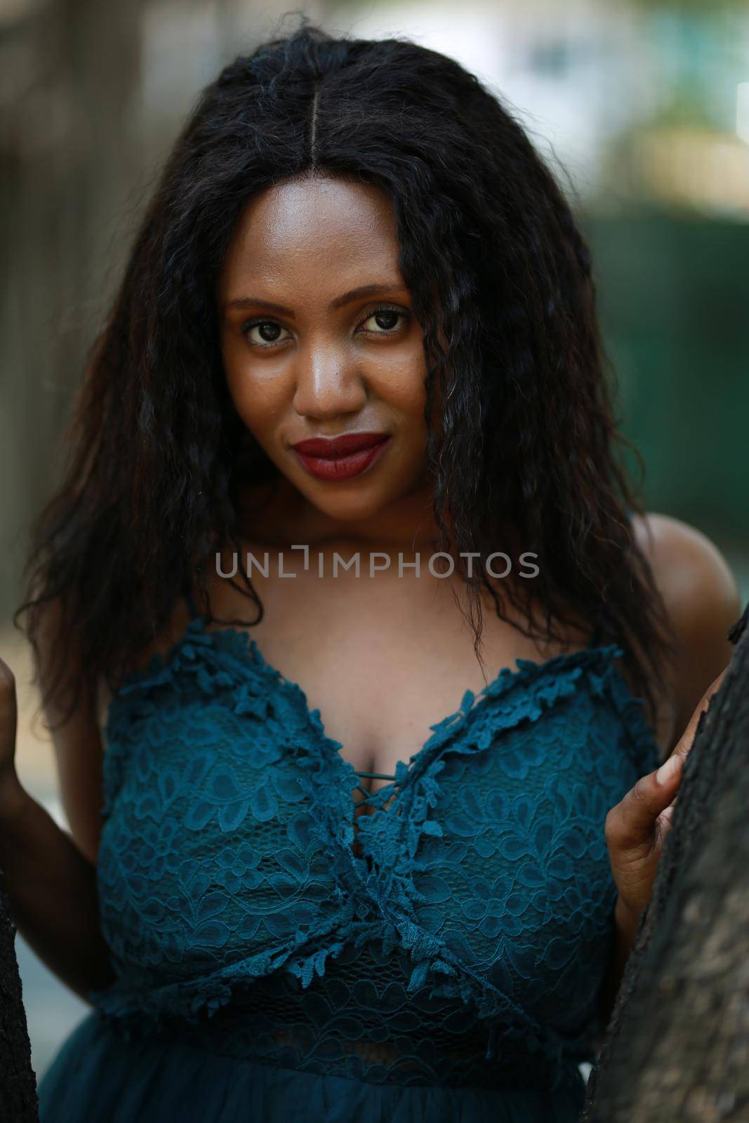 Cheerful young Afro American woman standing in tropical garden. by chuanchai