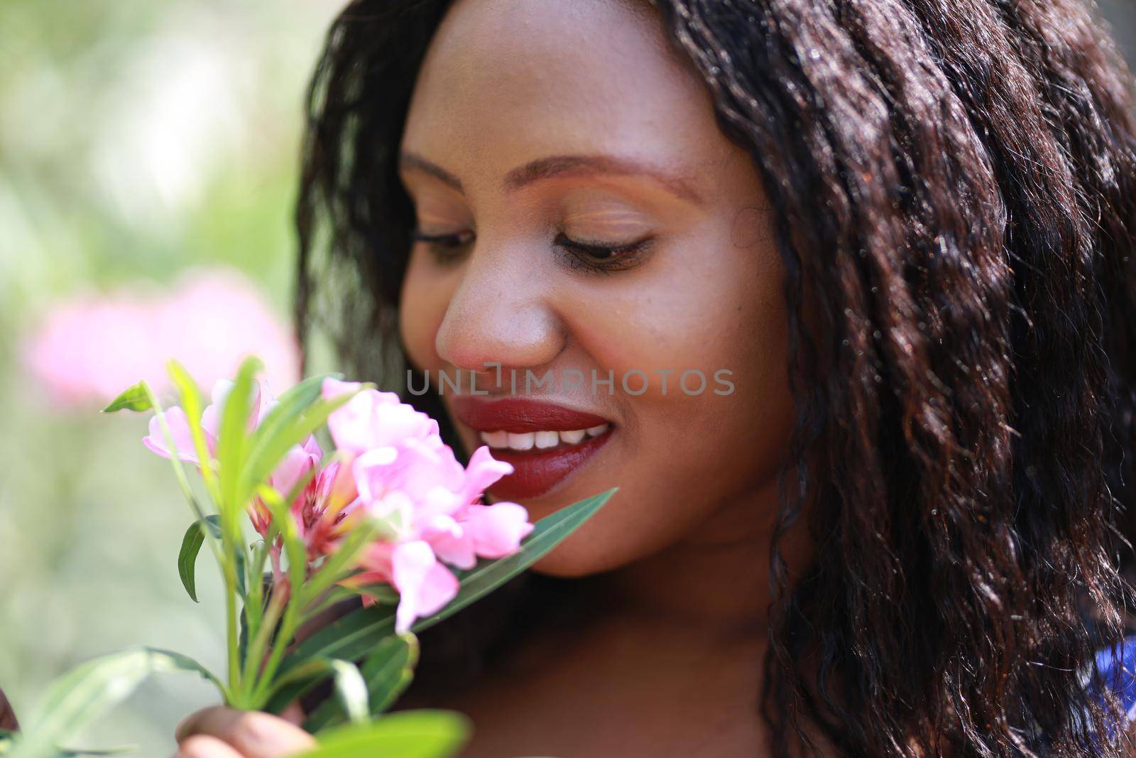 Cheerful young woman standing at outdoor with flower.