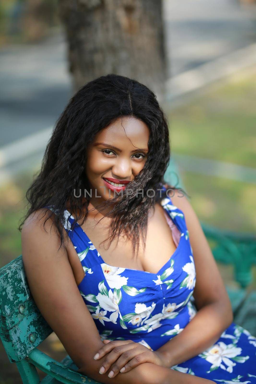 Cheerful young woman standing at outdoor with flower.