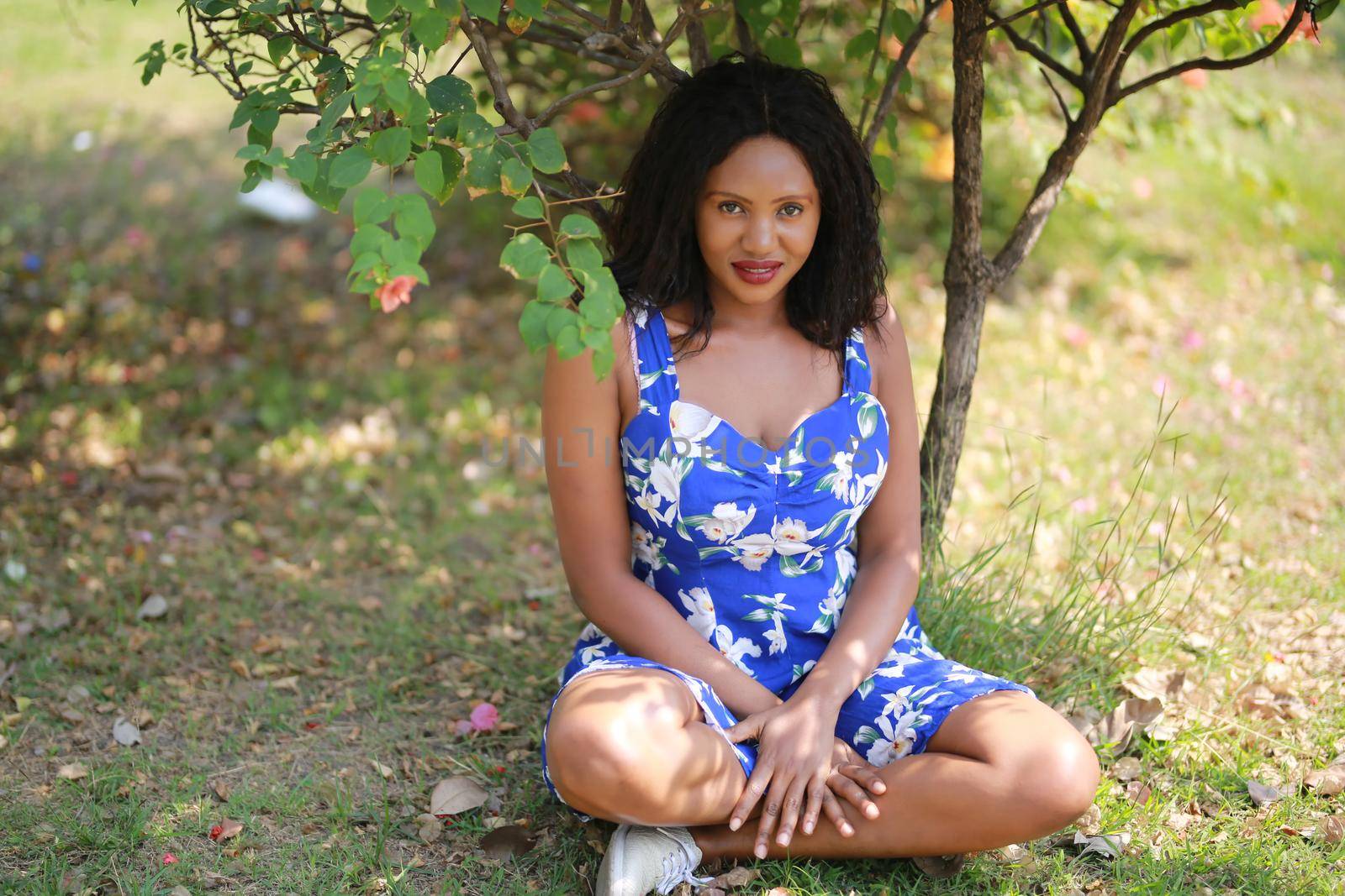 Cheerful young woman standing at outdoor with flower.