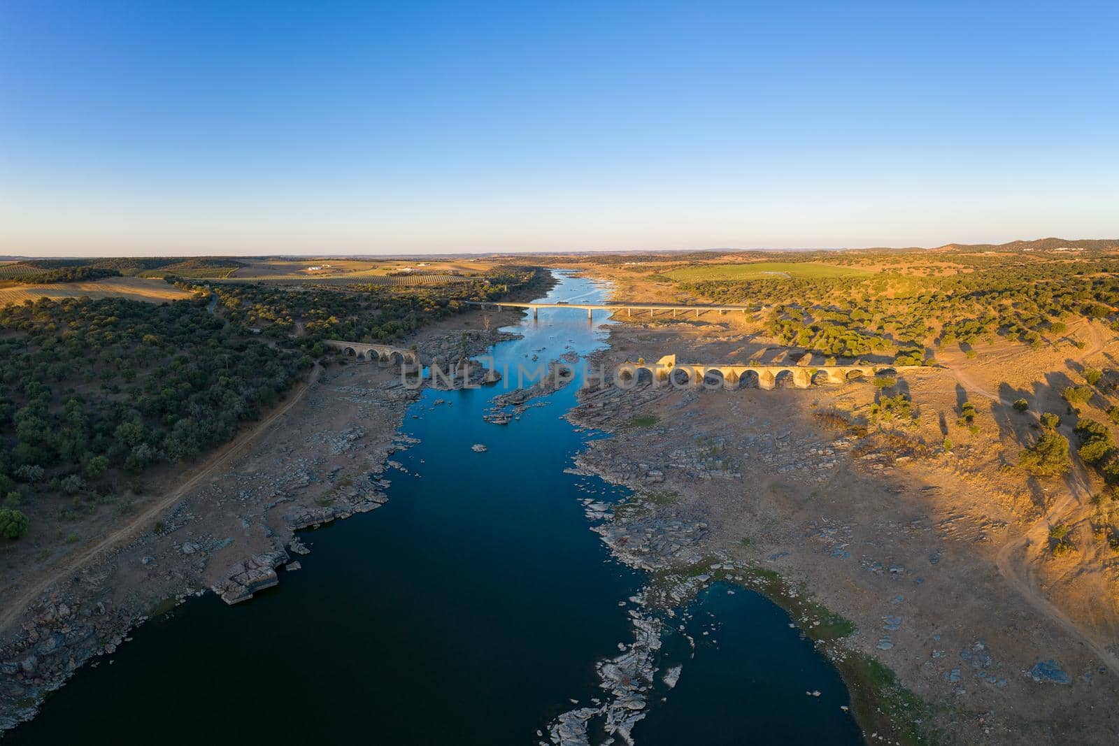 Destroyed abandoned Ajuda bridge drone aerial view, crossing the Guadiana river between Spain and Portugal