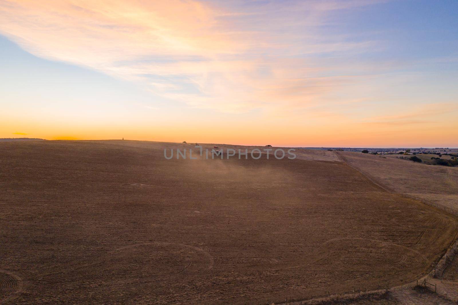 Tractors on a rural field drone aerial top view at sunset in Alentejo, Portugal by Luispinaphotography