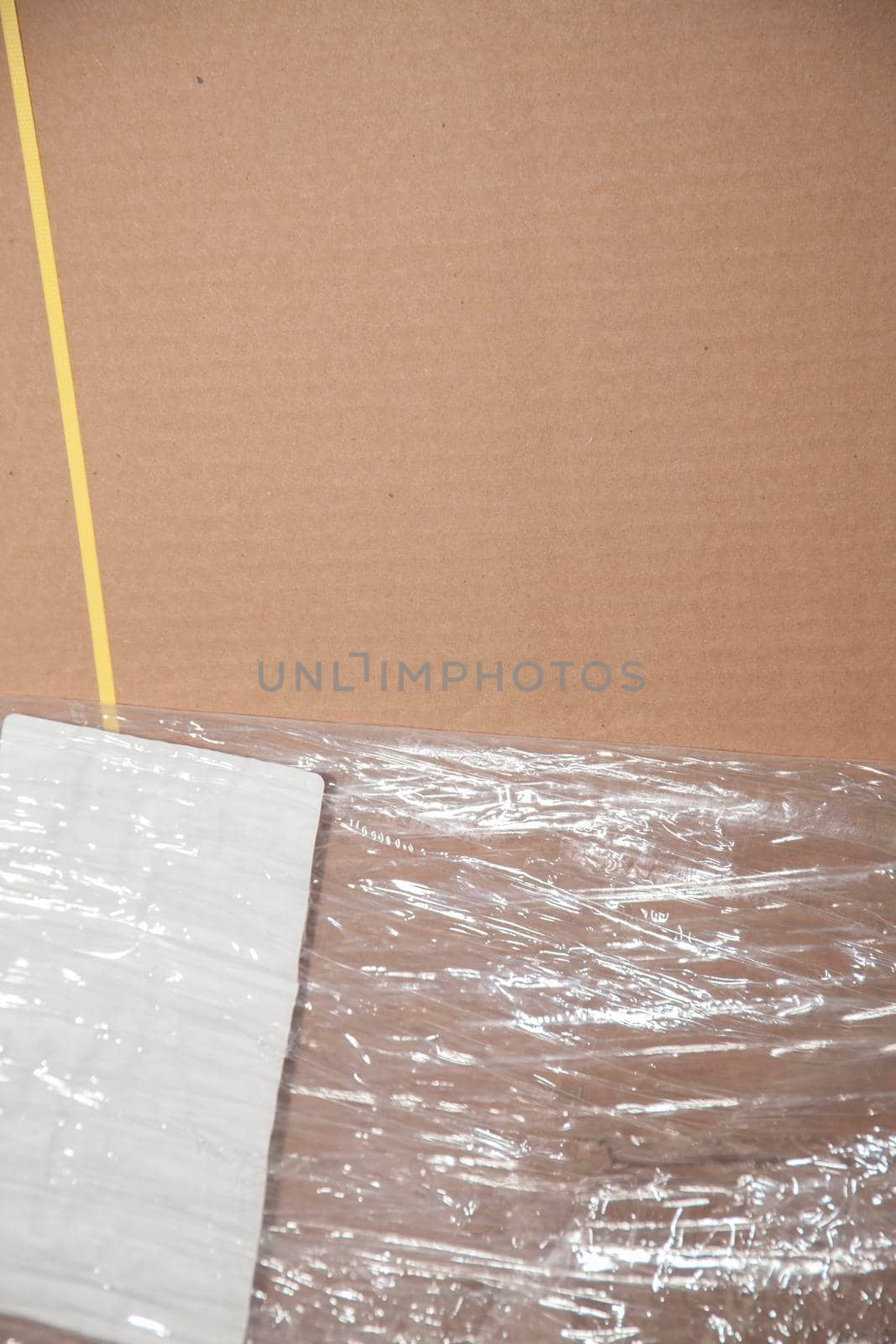 Unused, flattened cardboard boxes in an open plastic package with yellow bounding