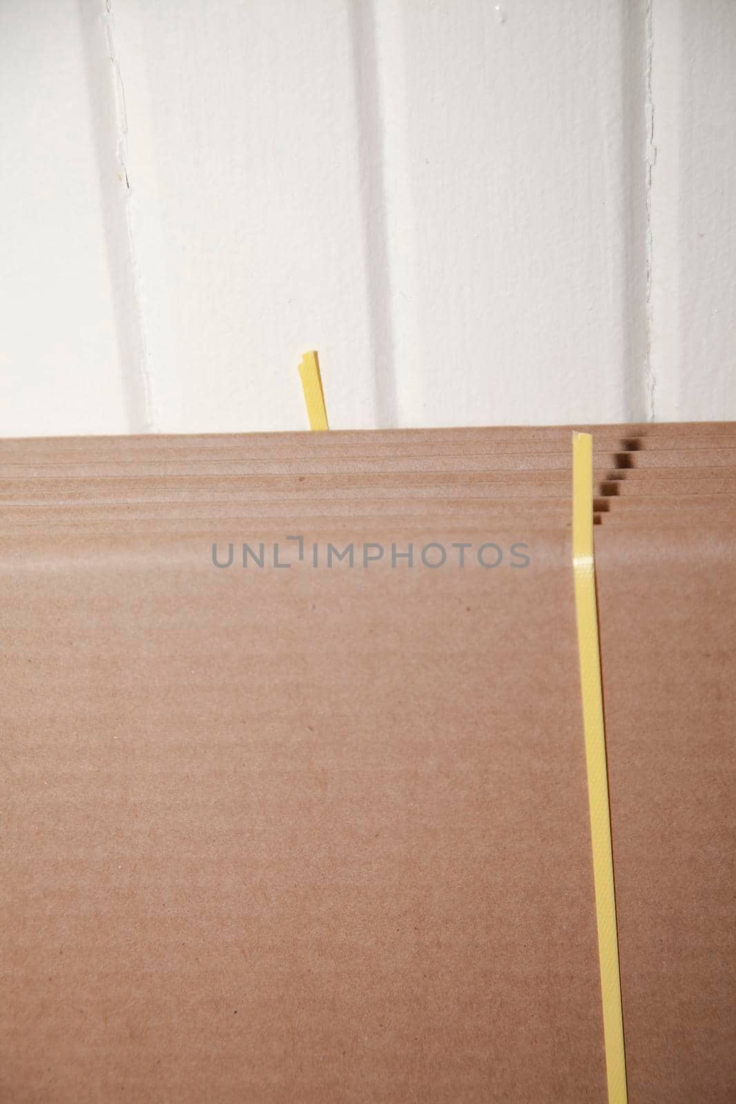 Seven unused, flattened cardboard boxes in an open package with cut yellow bounding