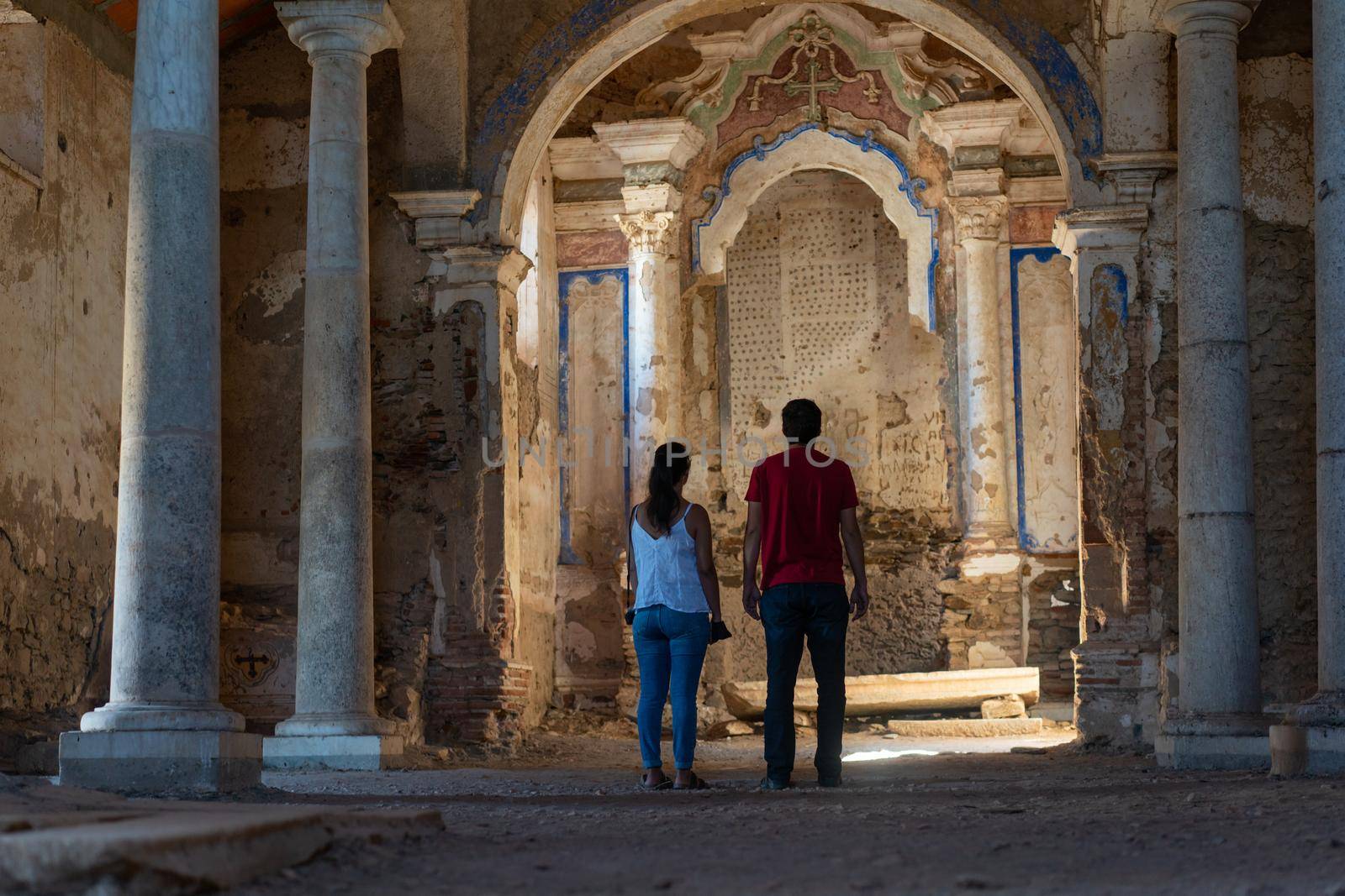 Caucasian couple in Juromenha abdandoned castle church interior in ruins in Alentejo, Portugal by Luispinaphotography