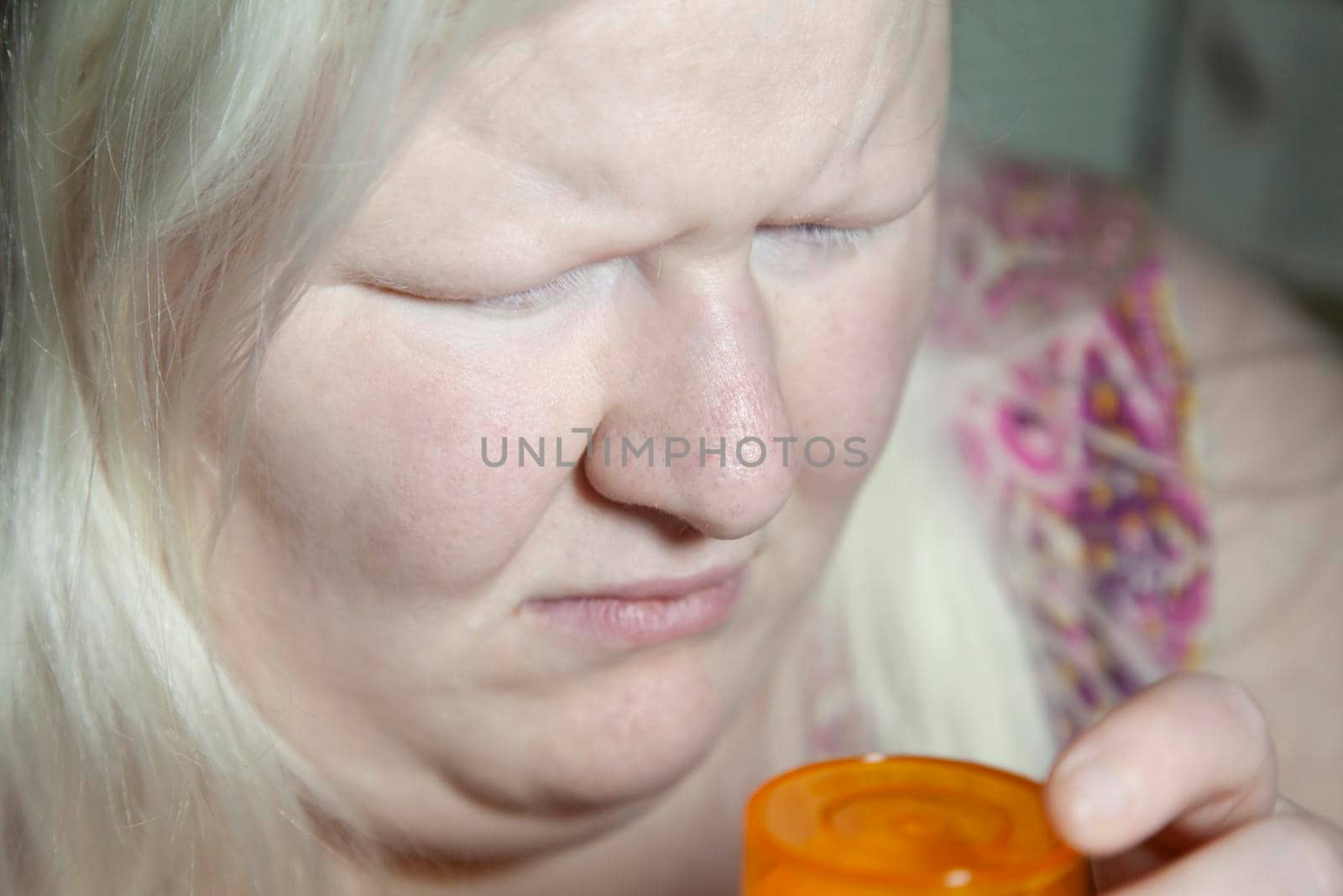Woman looking sadly at an empty medication bottle