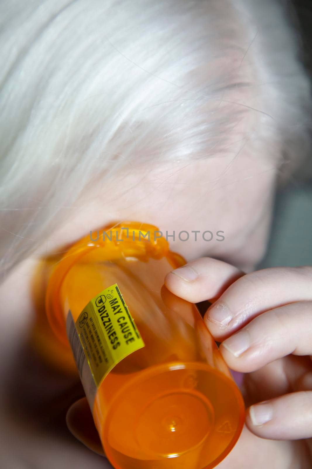 Woman looking desperately into an empty medication bottle