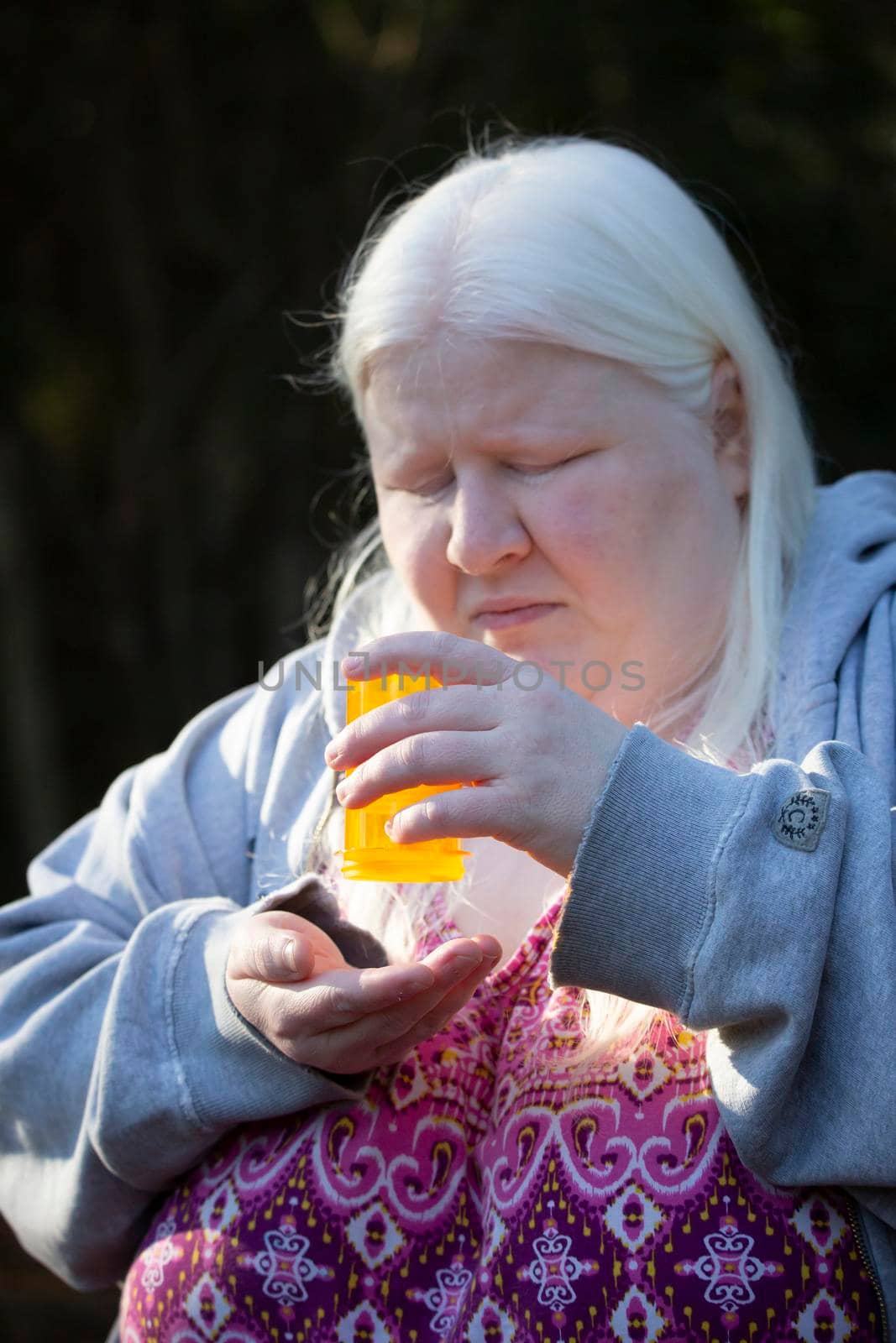 Woman desperately trying to get medication from an empty bottle