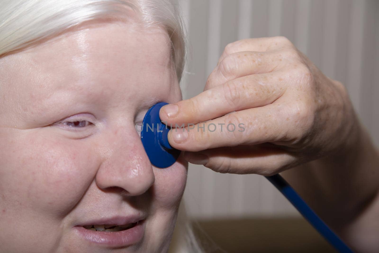 Medical professional holding a stethoscope up to a patient's eye