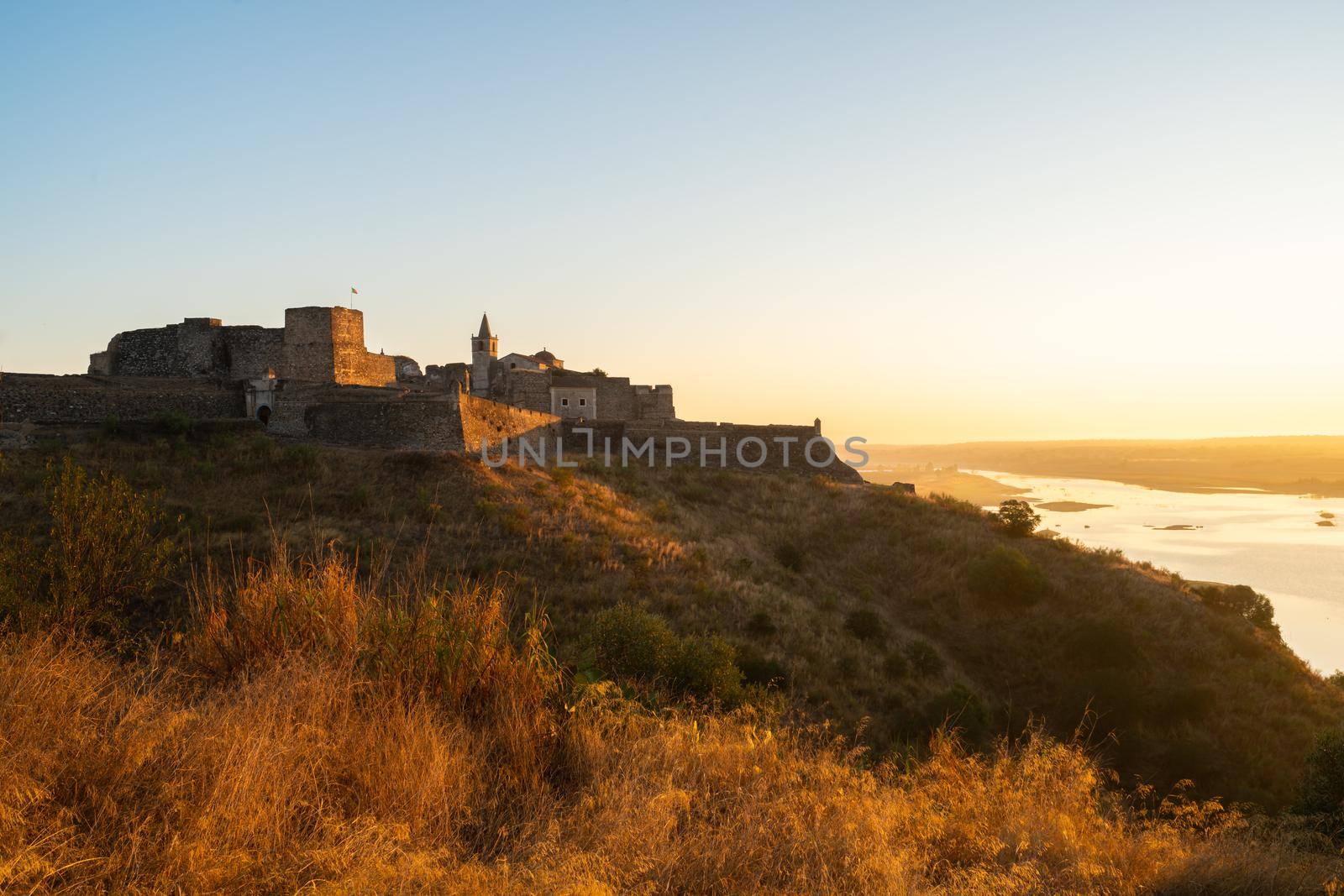 Juromenha castle and Guadiana river and border with Spain on the side of the river at sunrise, in Portugal