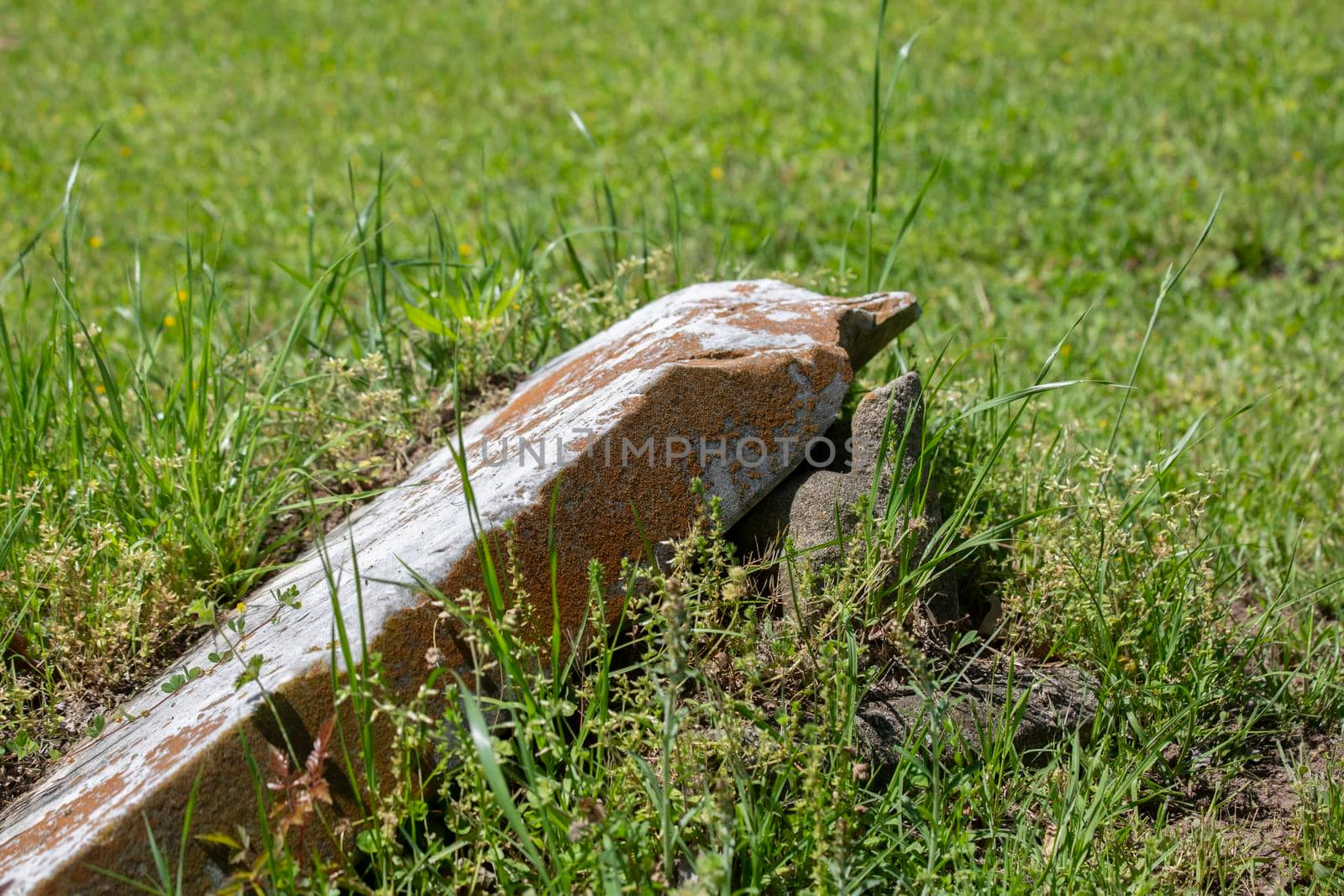 Close up of an old, broken tombstone in a field