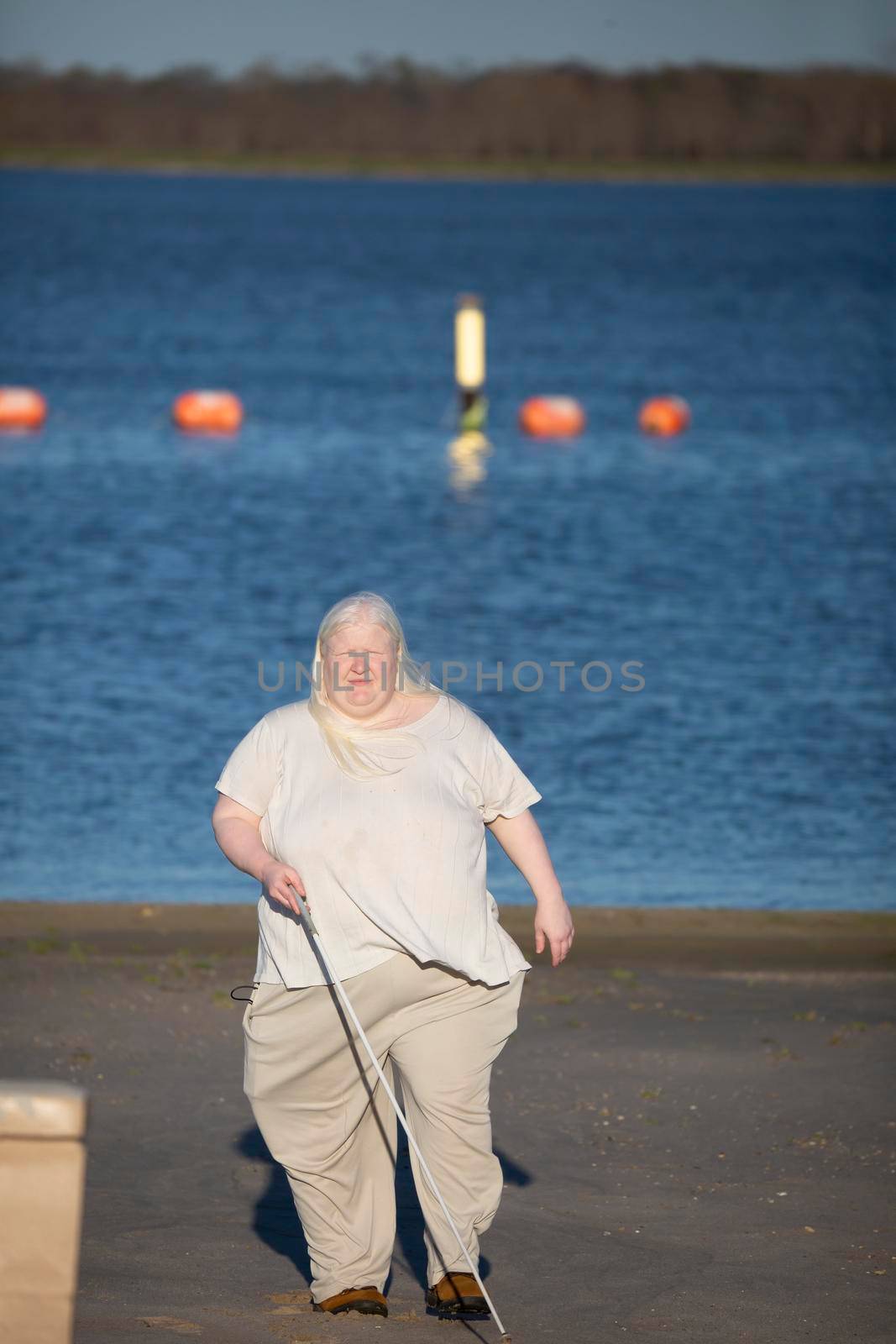 Blind woman walking away from a swimming area