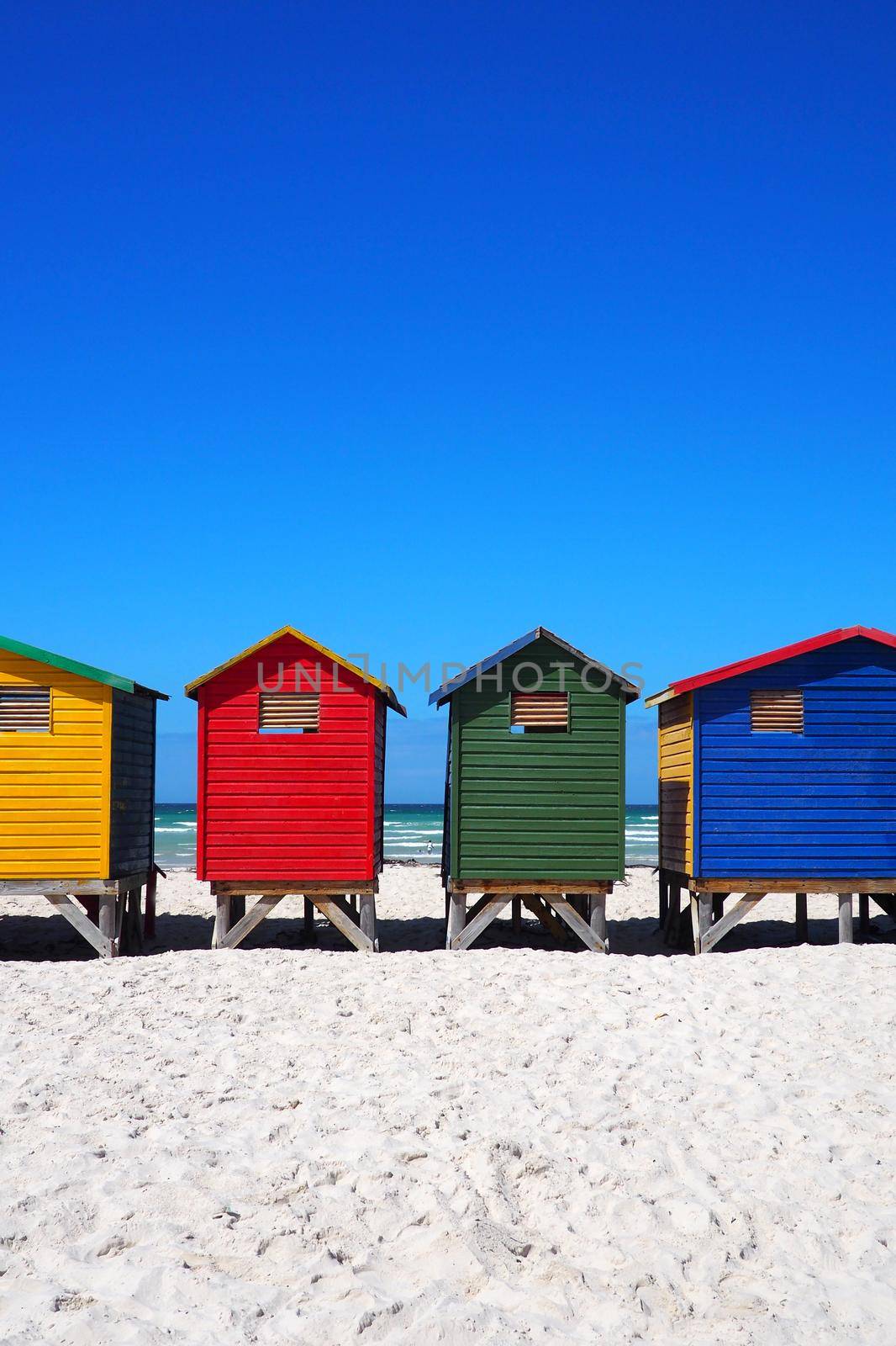 Row of colored beach huts by fivepointsix