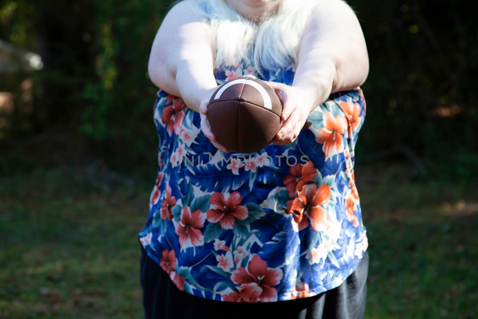 Woman holding a football out, preparing to punt