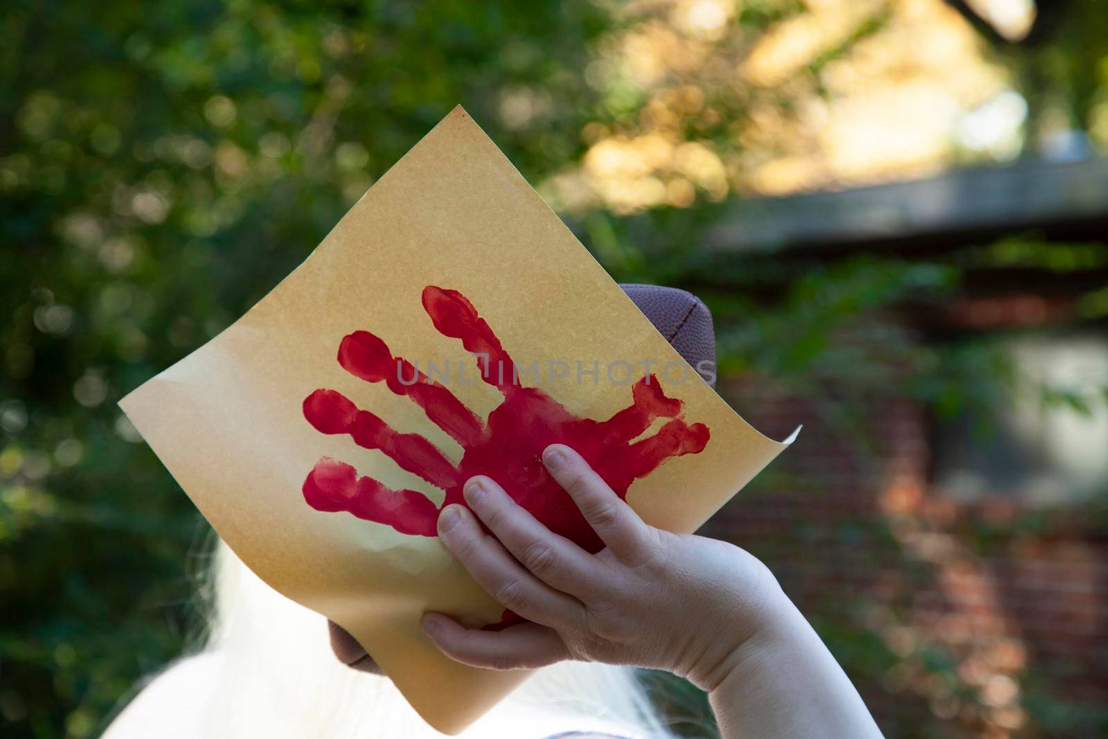 Woman preparing to throw a football wrapped in a paper hand-turkey