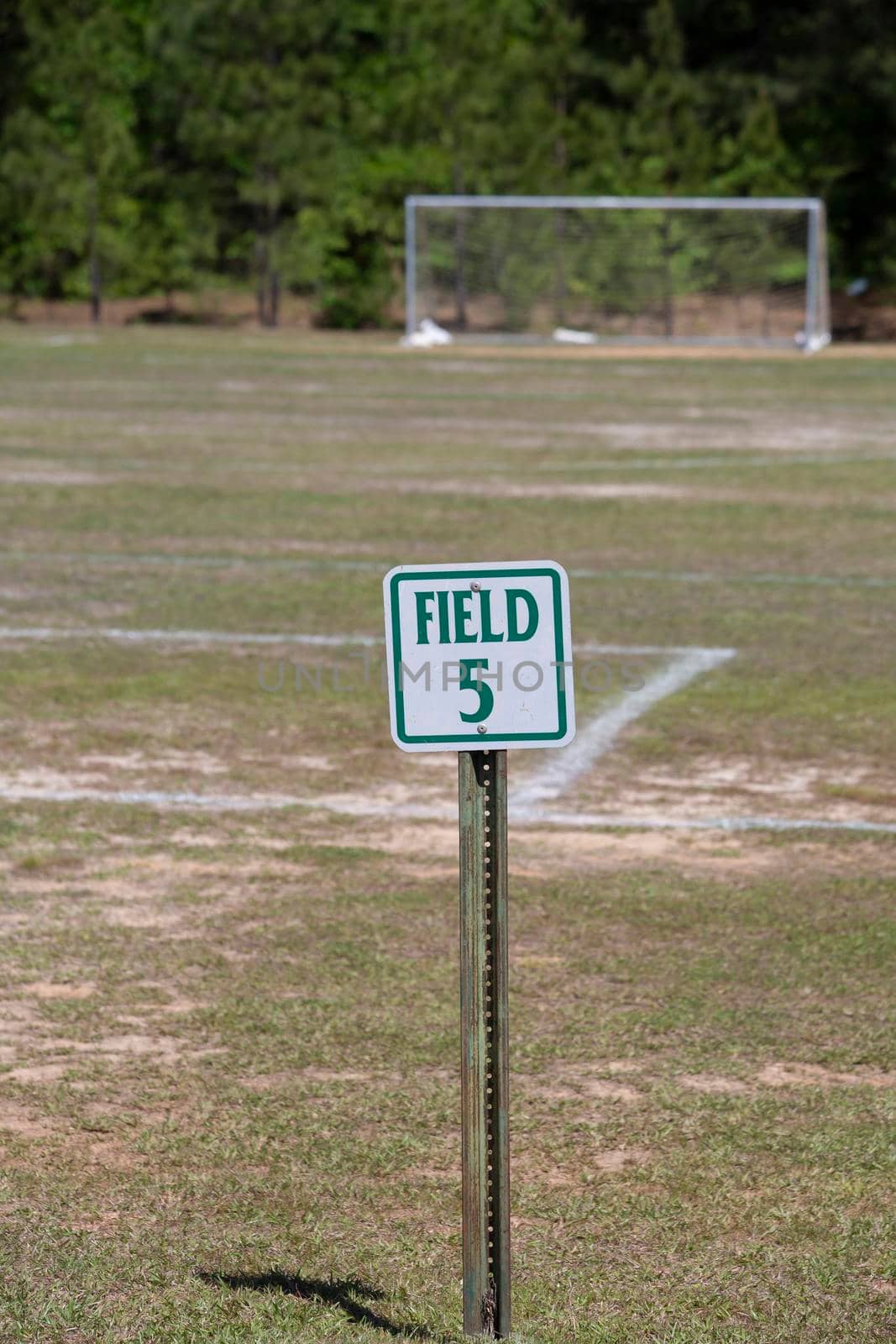 Field number sign with a soccer goal in the background