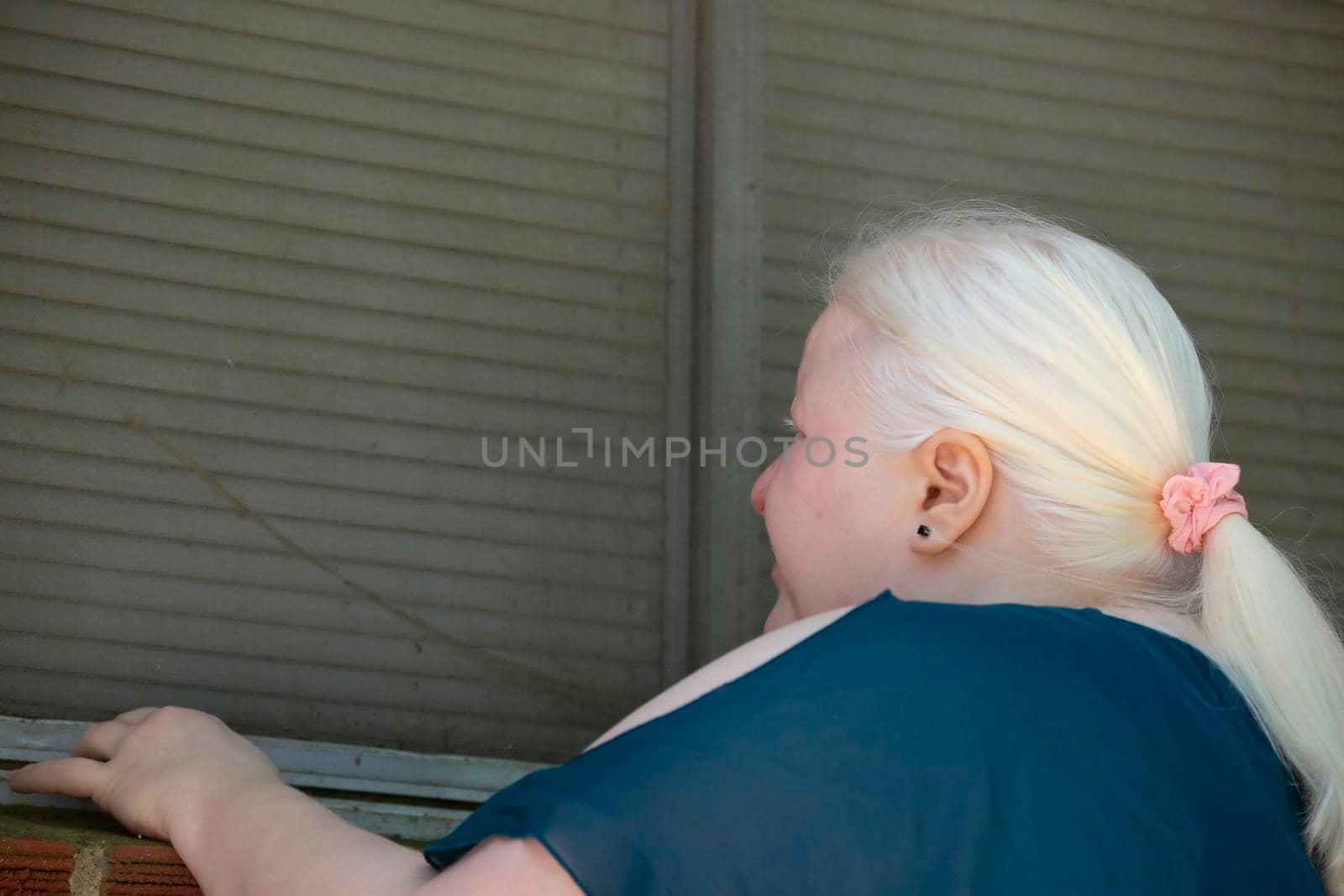 Legally blind woman checking a window for damage