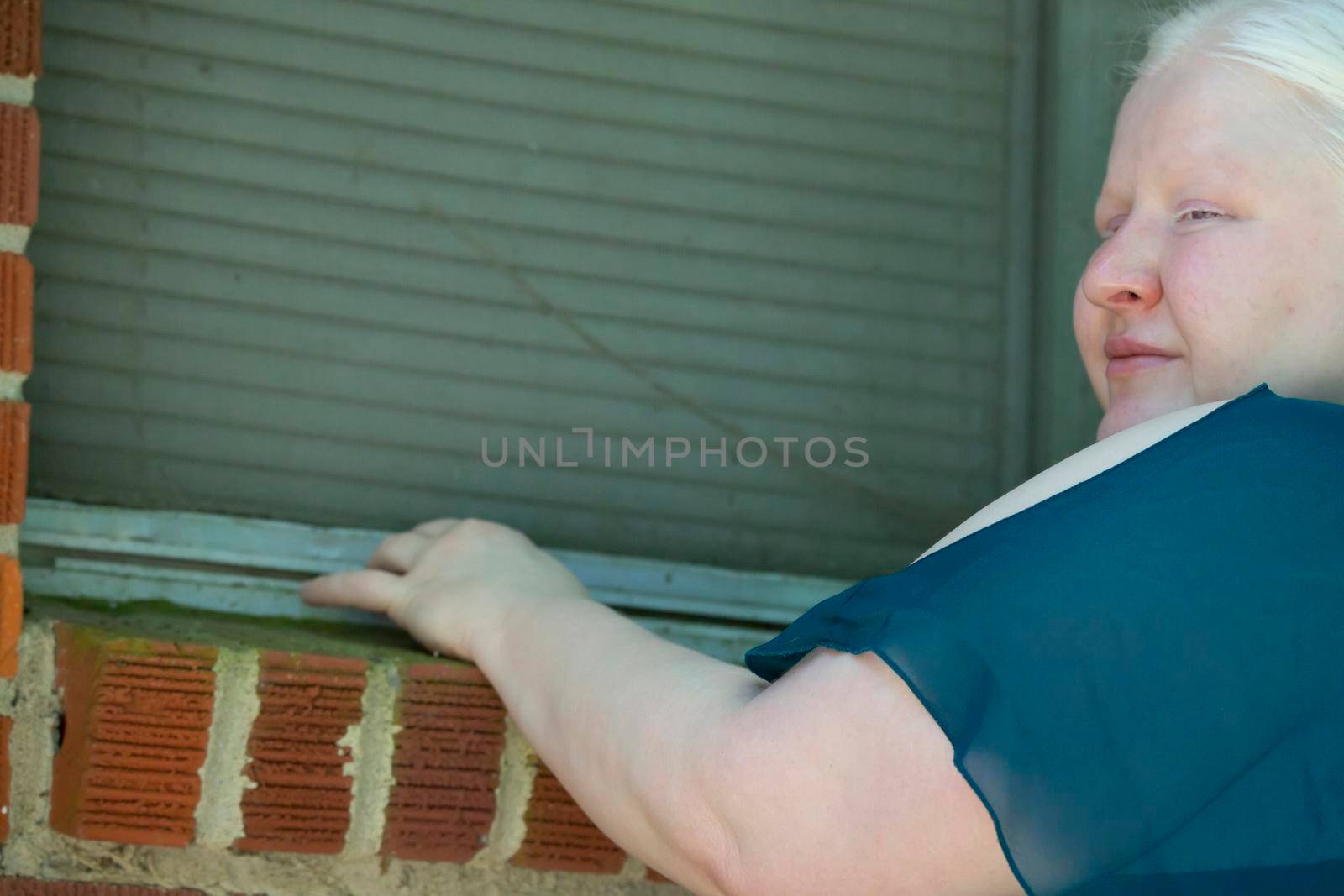 Legally blind woman checking a window for damage