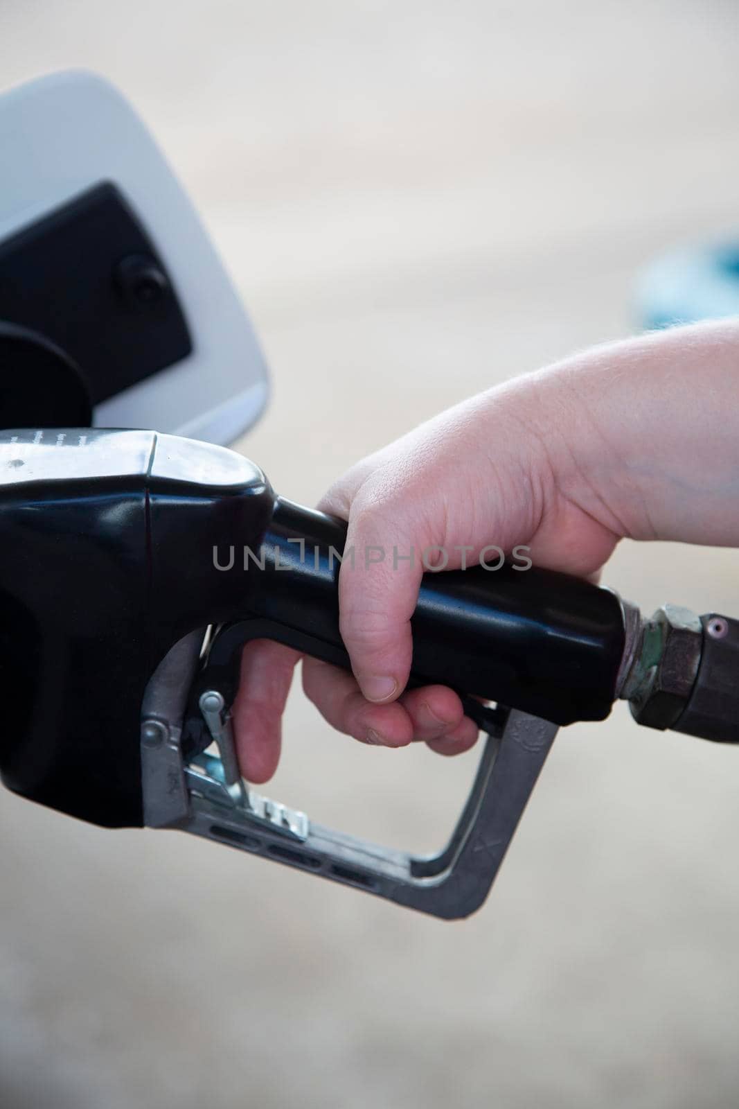 Woman's hand pushing a generic gas pump handle