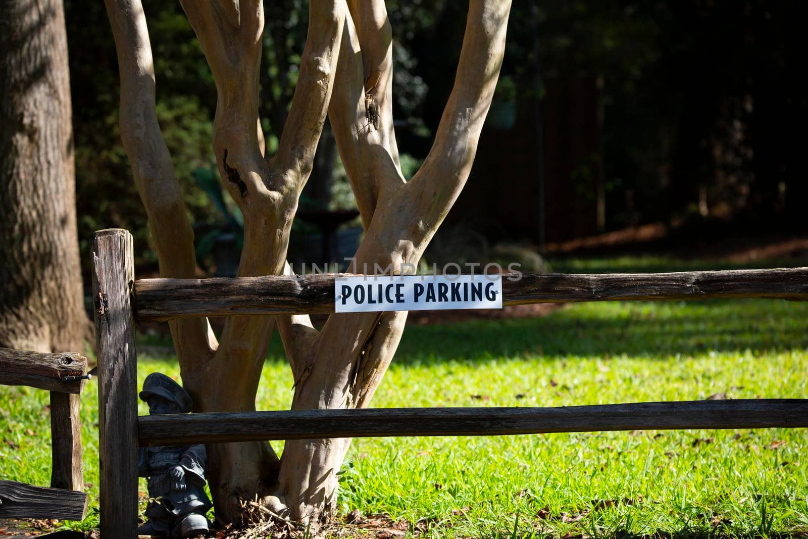 White and black police parking sign on a wooden fence