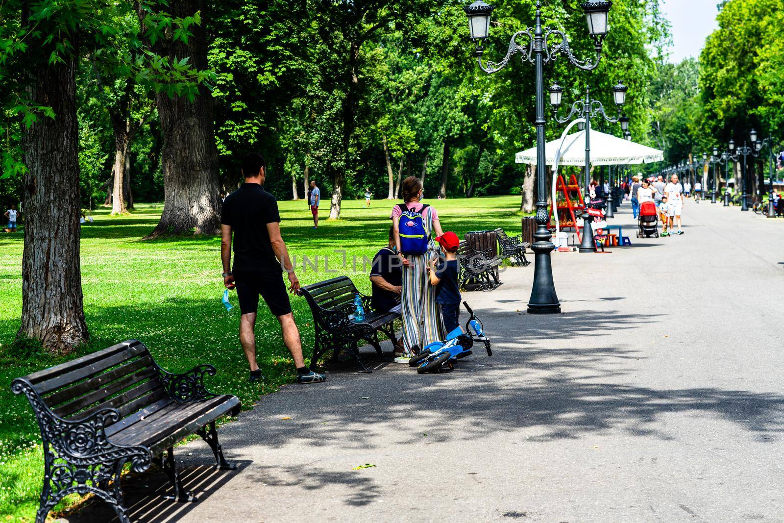 People walking, relaxing and have fun on the alleys of park and gardens of the domain from Mogosoaia in Bucharest, Romania, 2020. by vladispas