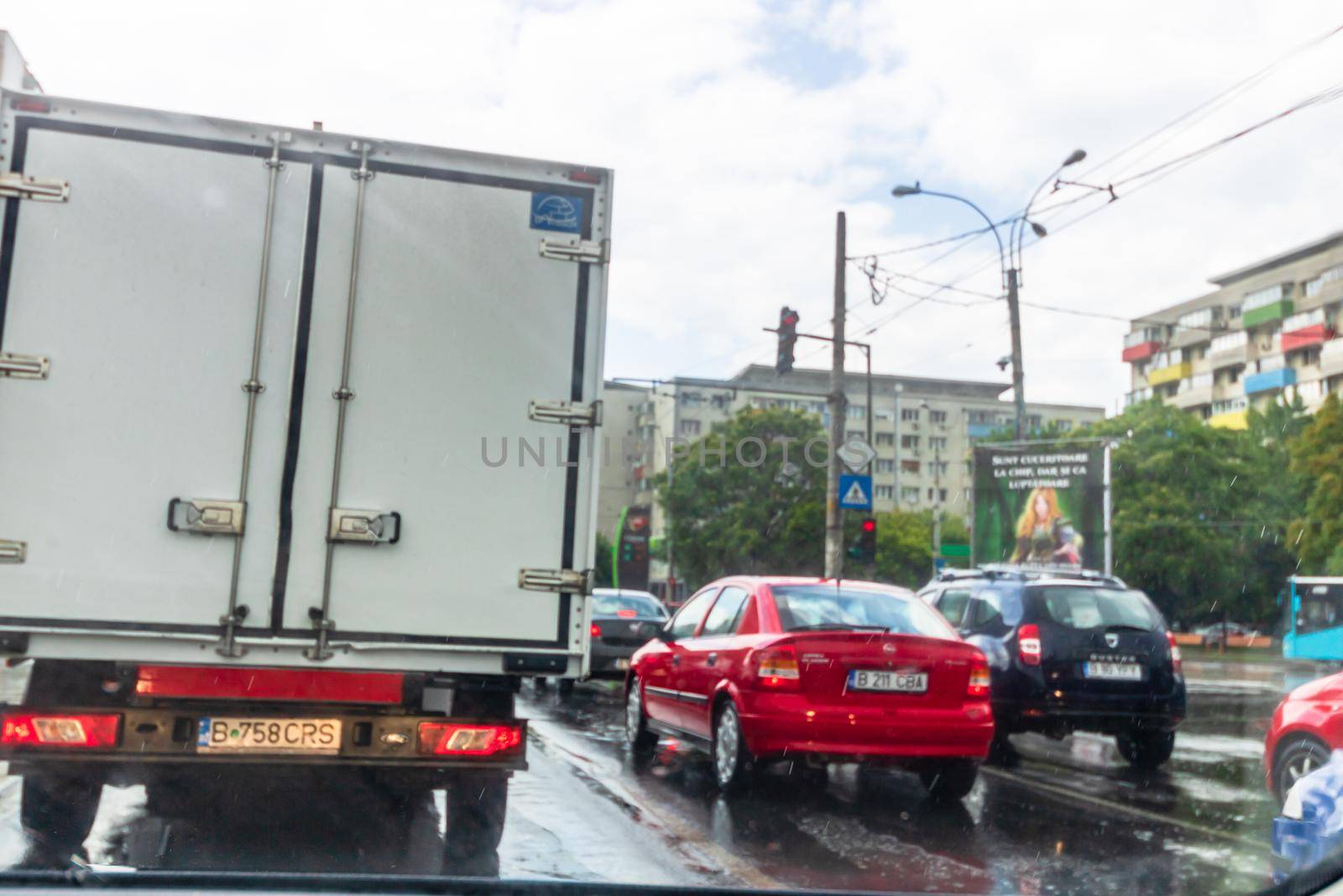Traffic in cloudy rainy day with road view through car front window in Bucharest, Romania, 2020