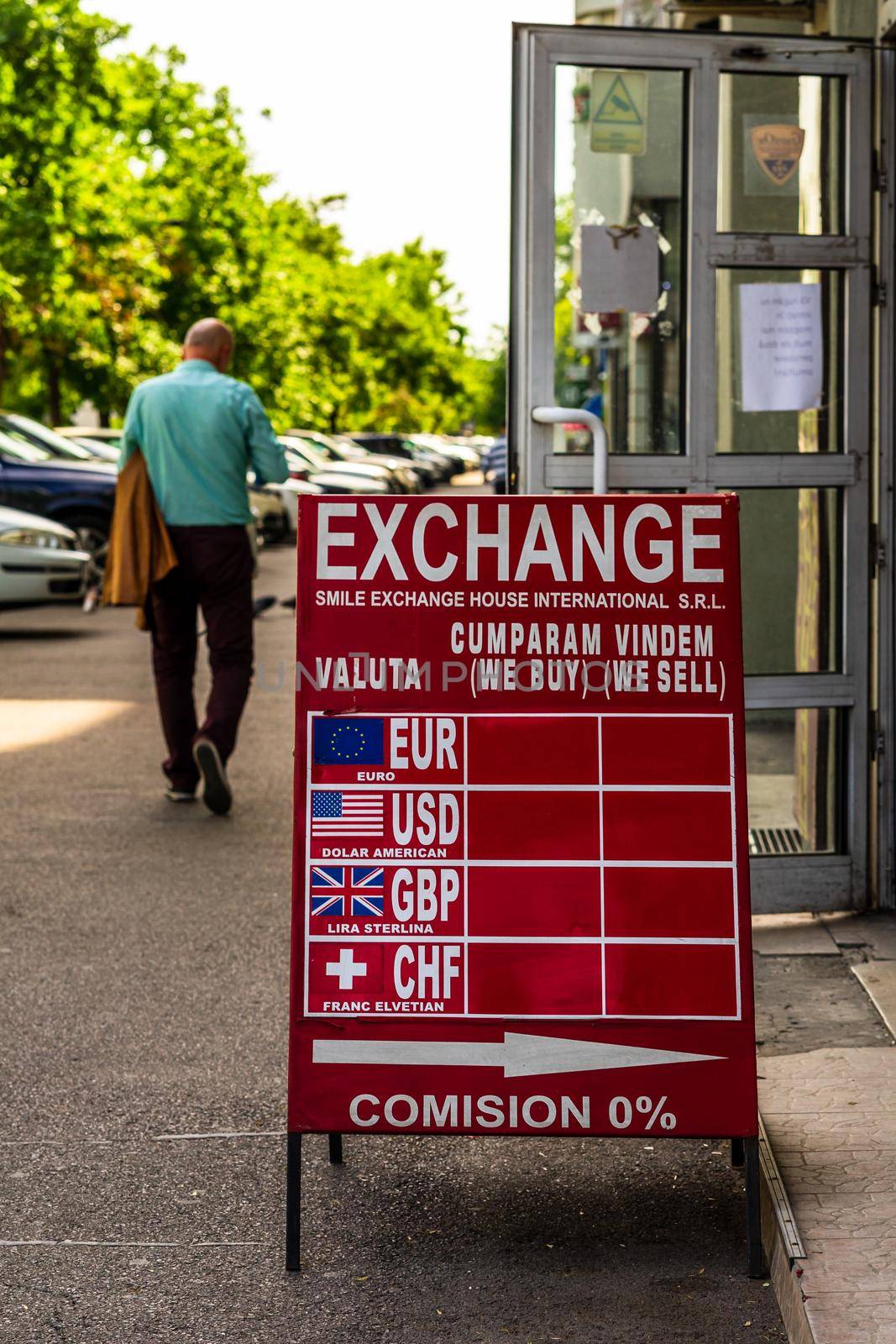 The exchange rate of the main currencies is displayed on a red board at the entrance of a currency exchange office in Bucharest, Romania, 2020 by vladispas