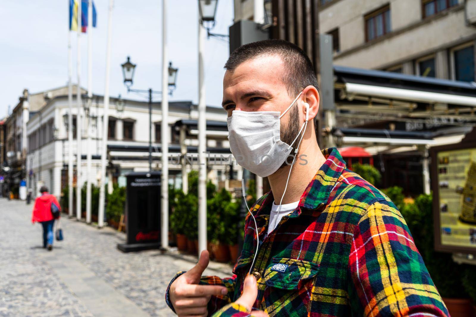 Funky hipster young man wearing medical mask in Bucharest, Romania, 2020