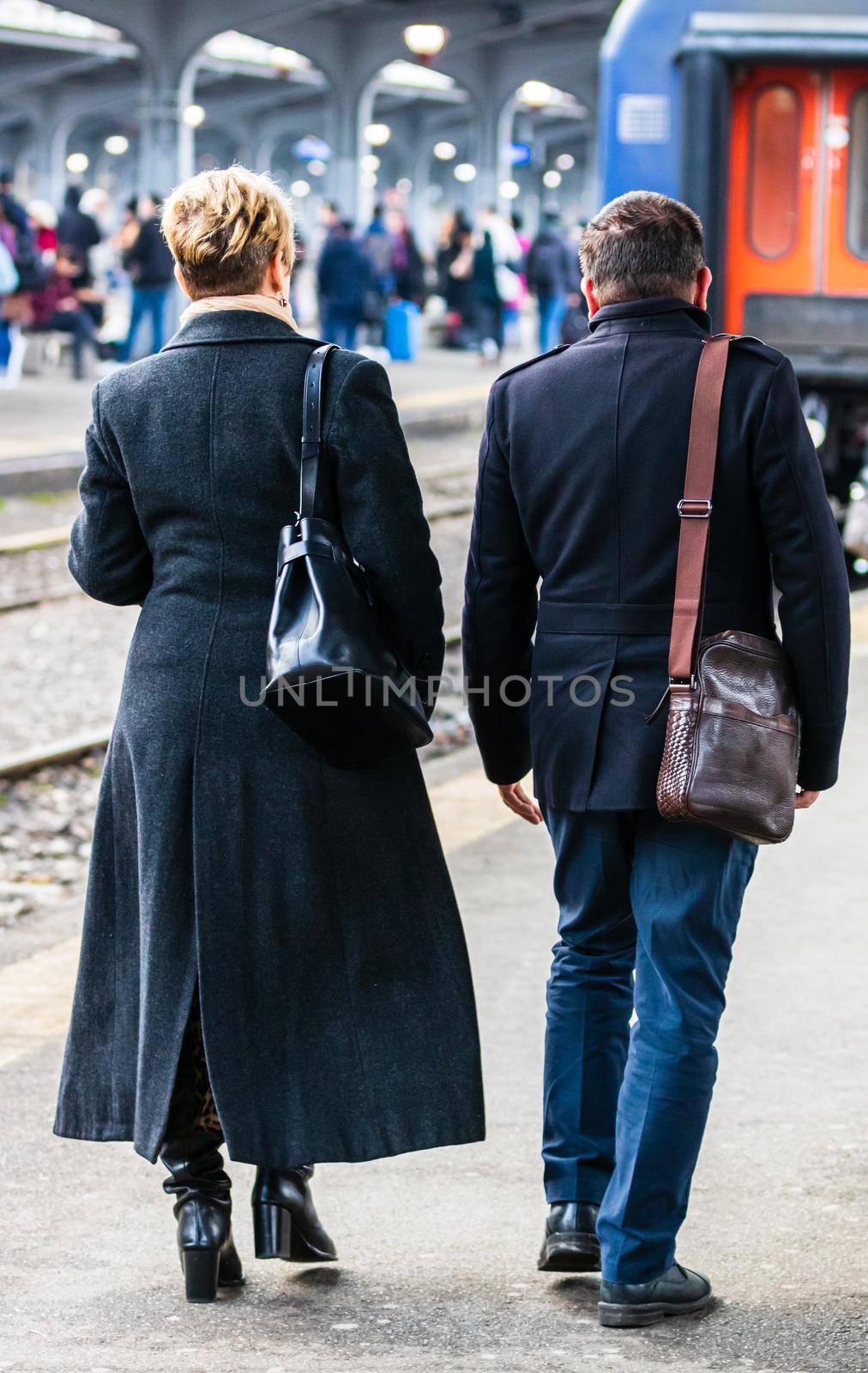 Couple on their way to the train platform at Bucharest North Railway Station (Gara de Nord Bucharest) in Bucharest, Romania, 2020 by vladispas