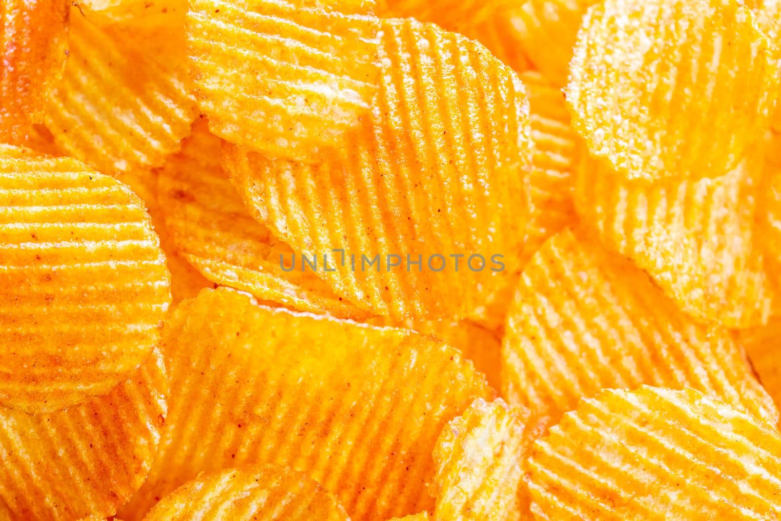 Background of yellow golden grooved fried potato chips by galinasharapova