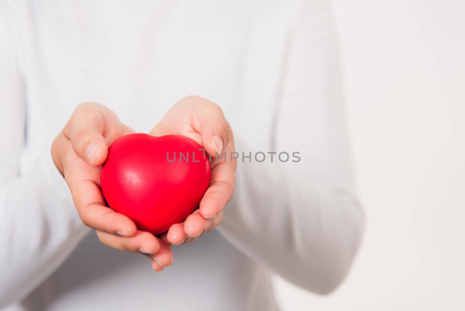 Woman beauty hands holding red heart for giving by Sorapop