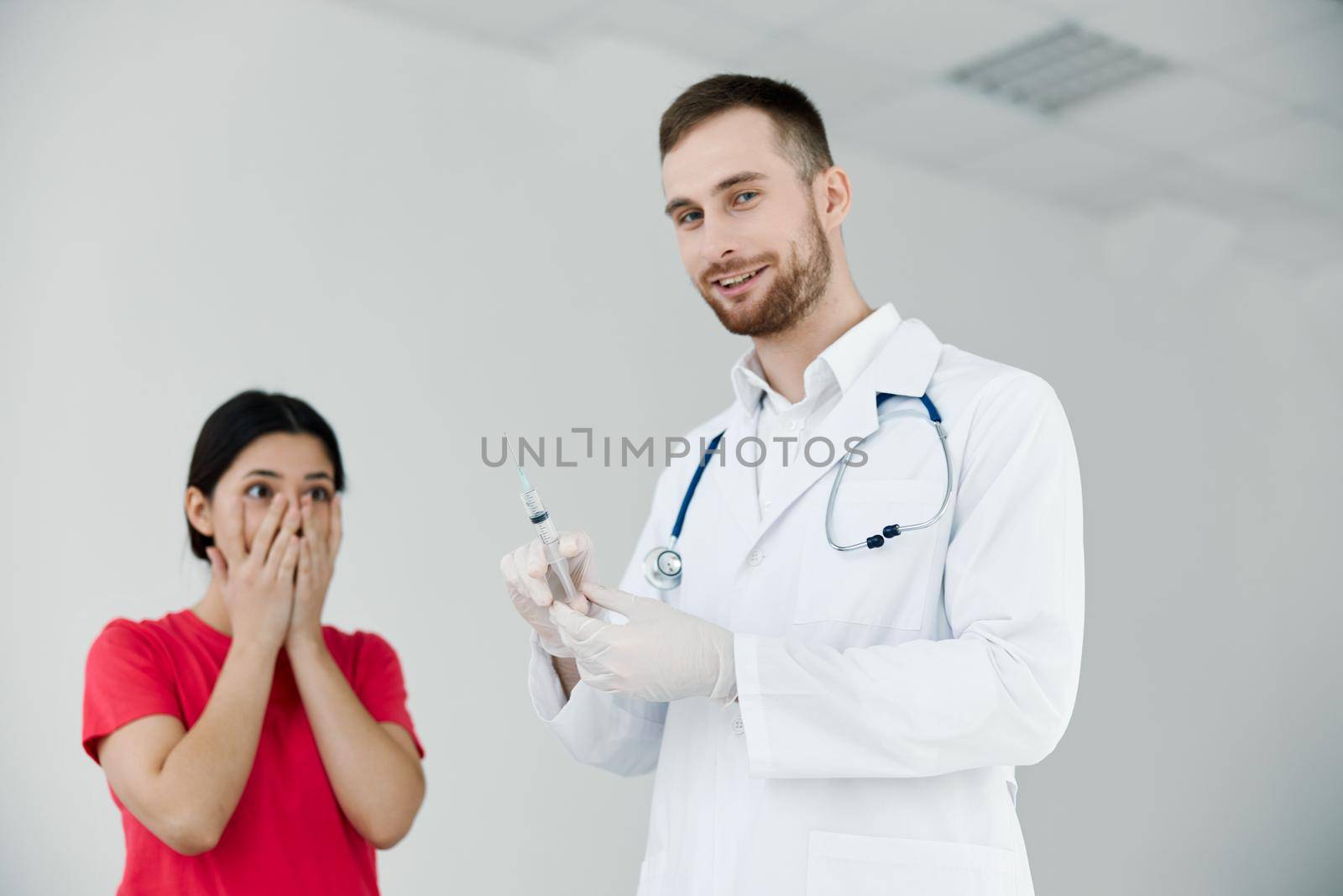 male doctor holding a syringe in his hands the patient is afraid of injections. High quality photo