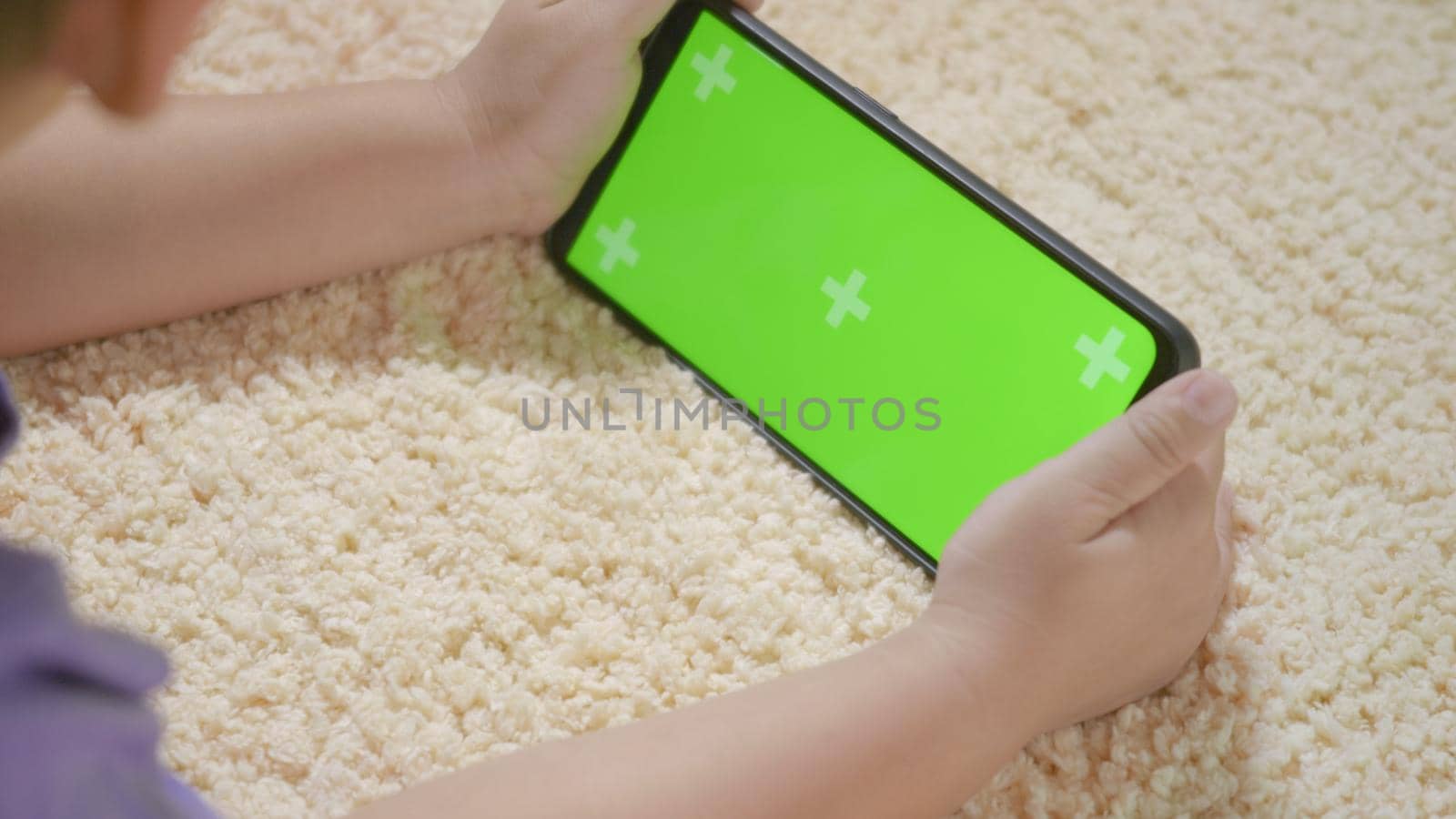 Asian kid boy preschool with gadget playing video games digital on mobile phone at home. Little child using and holding a smartphone green screen in hand, Technology generation concept