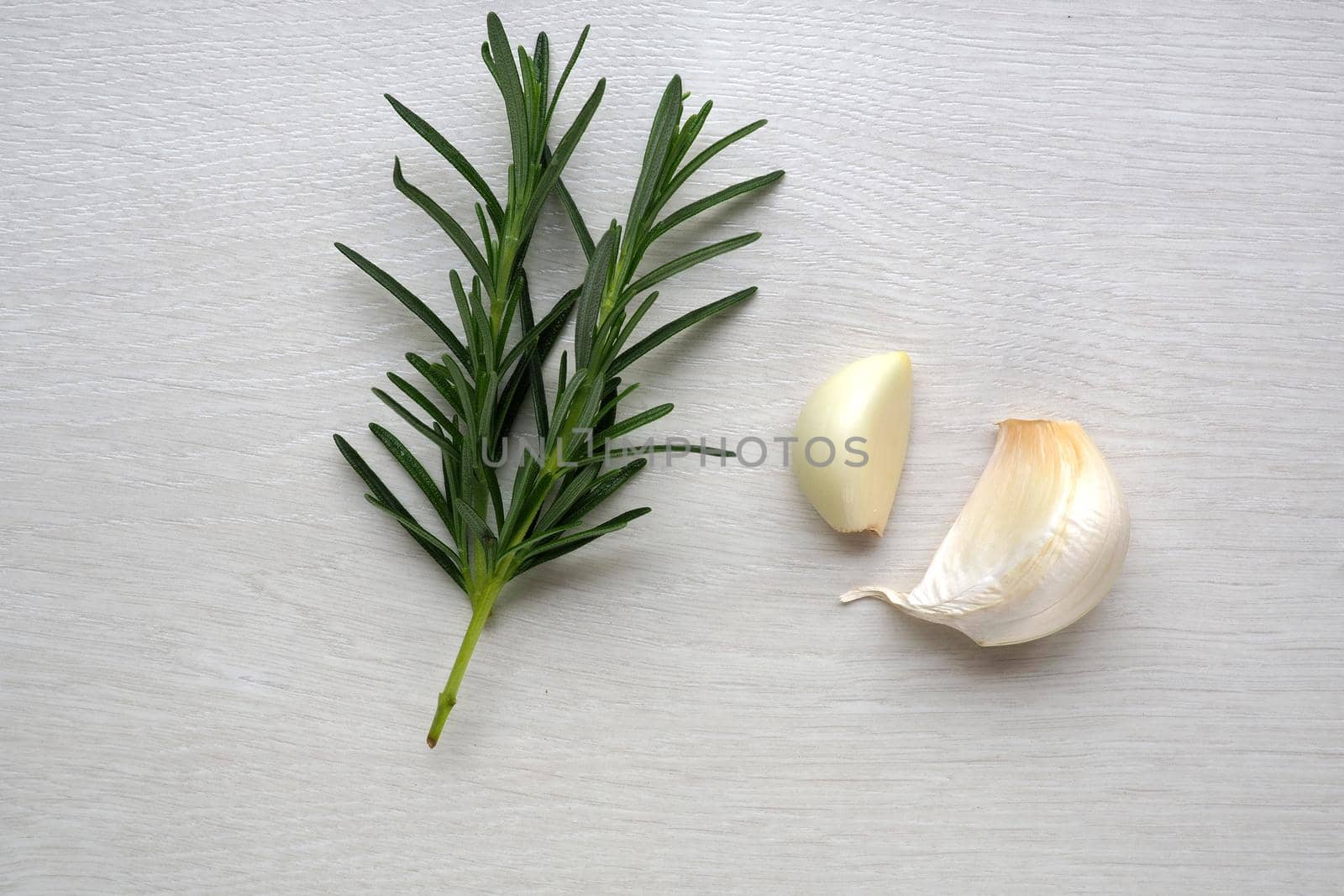 garlic clove and rosemary on white background by fivepointsix
