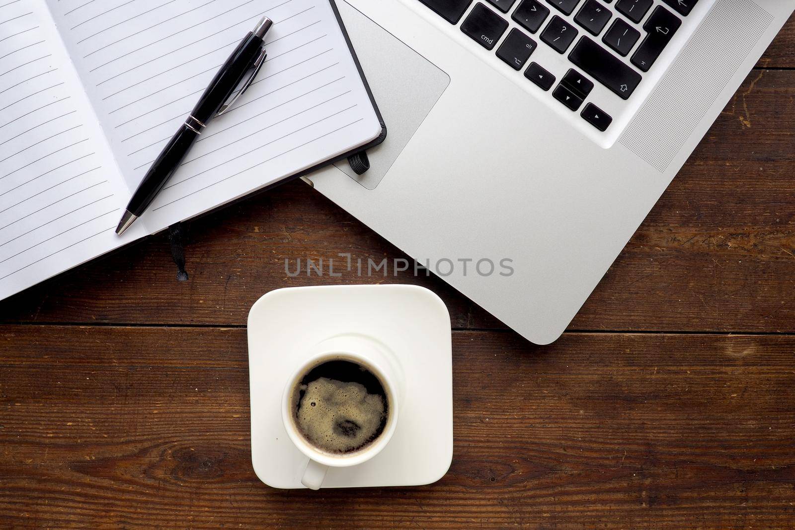 Coffee and notepad with computer, wooden desk by fivepointsix