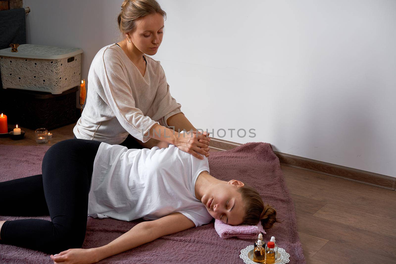 Relax and enjoy in spa salon getting thai massage by professional masseur Woman lying floor blanket Body care Hands treatment Acupressure trigger points Prevention muscles pain stretching flexibility