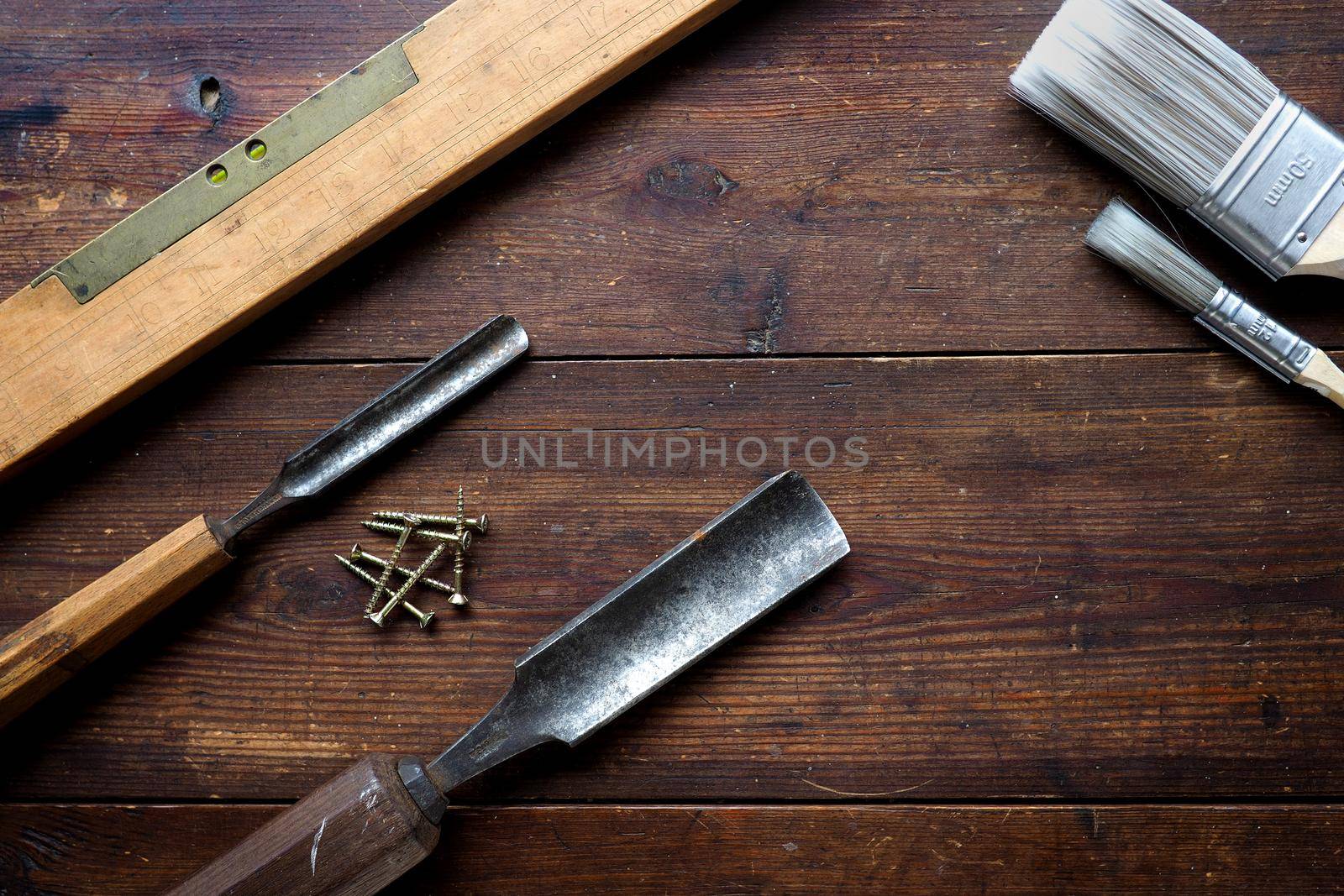 Wood chisels and spirit level on old table top by fivepointsix