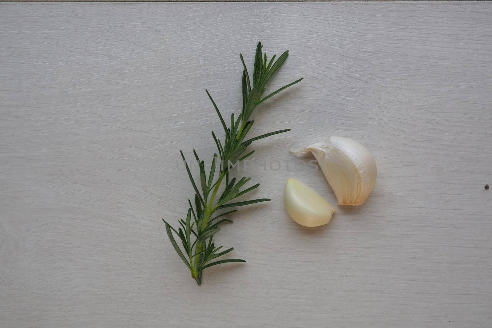 garlic clove and rosemary on white background by fivepointsix