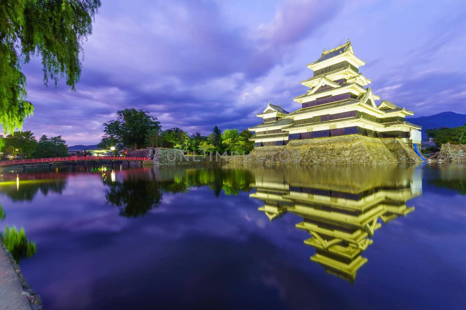 Night view of the Matsumoto Castle (or Crow Castle) and bridge, in Matsumoto, Japan
