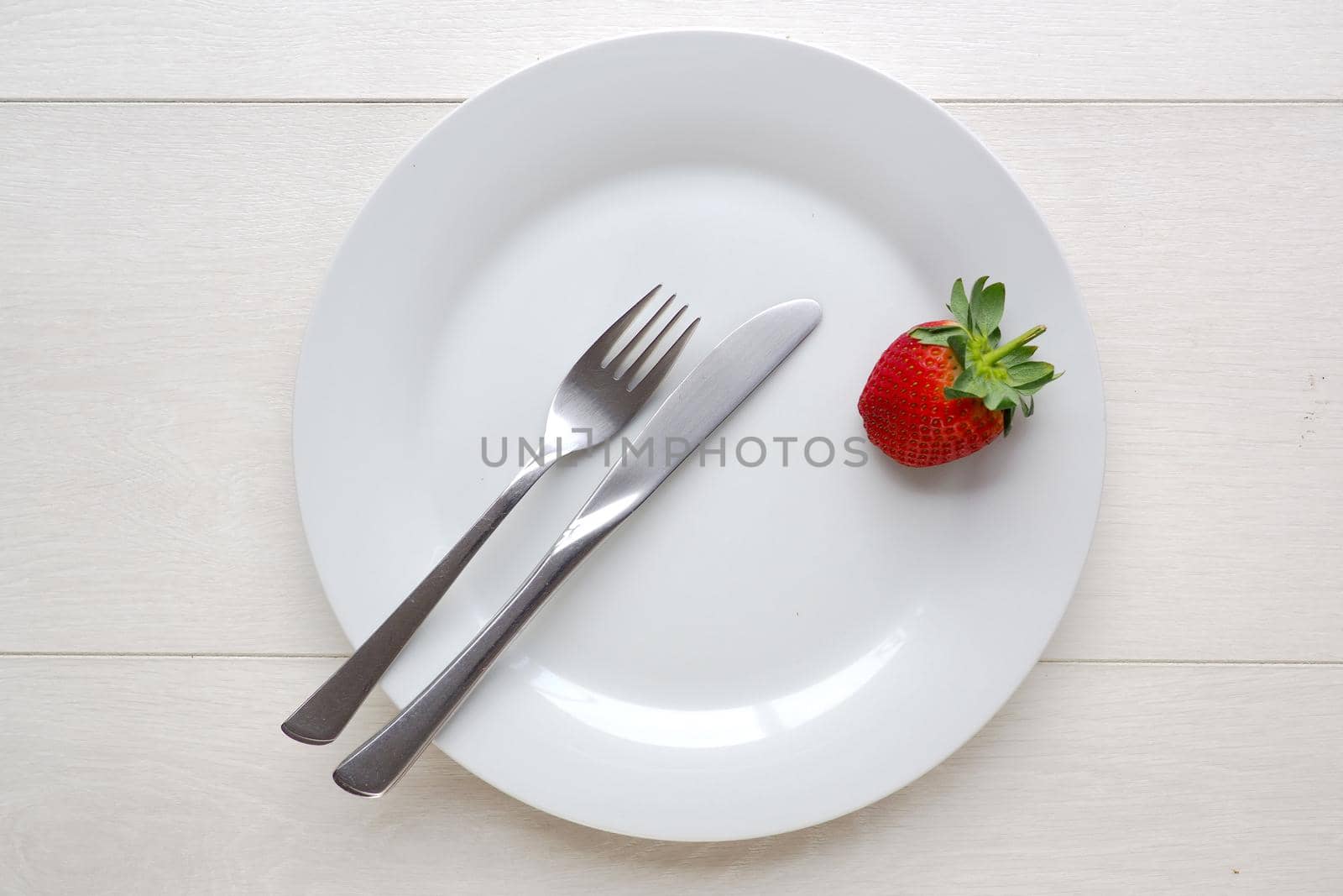 Red strawberry on blank plate, from overhead by fivepointsix