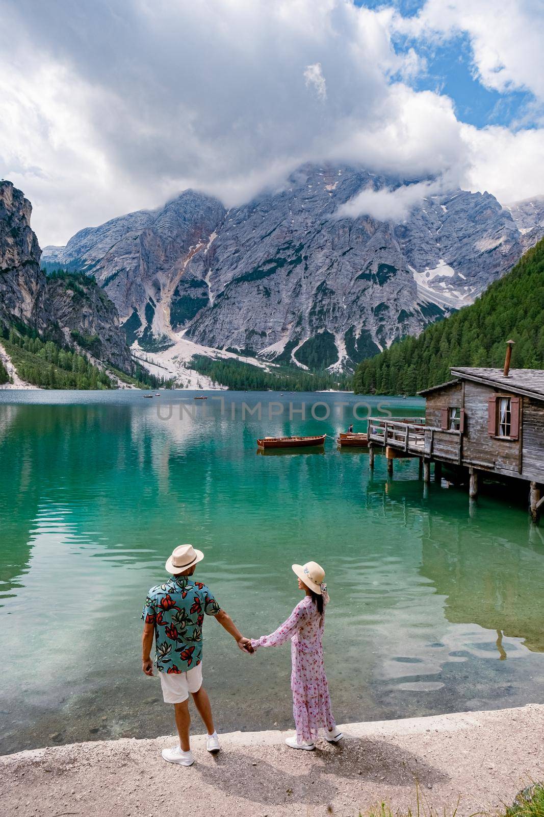 Beautiful lake in the Italian Alps, Lago di Braies in the Italian Dolomites Europe. Braies lake, Italy. The famous lake in the Dolomites, a couple of men and woman mid-age visit Prager wildsee rowing boat