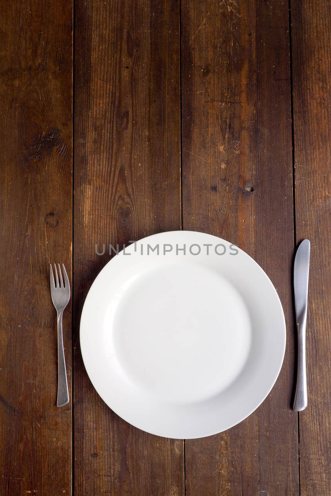 White plate on wooden background, copy space by fivepointsix