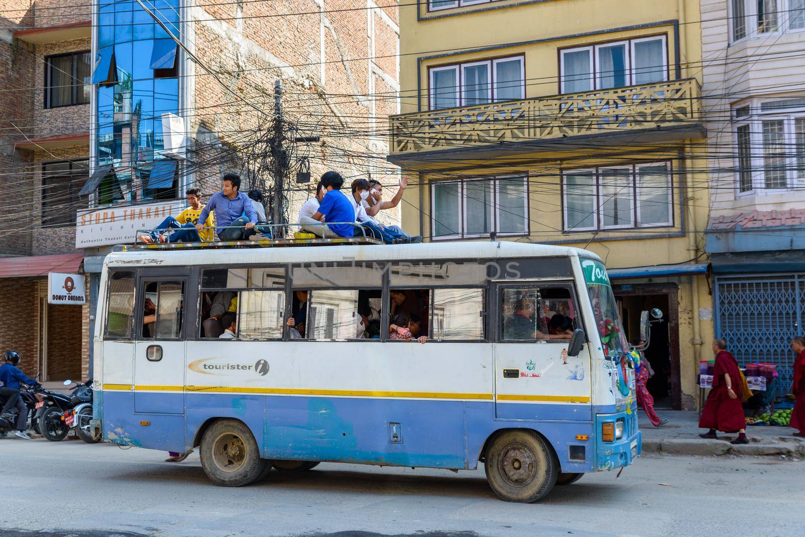 KATHMANDU, NEPAL - CIRCA NOVEMBER 2015: Men travel on top of a bus. Traveling on bus tops was authorized for a few months because of fuel shortage following a blockade at the India-Nepal border.
