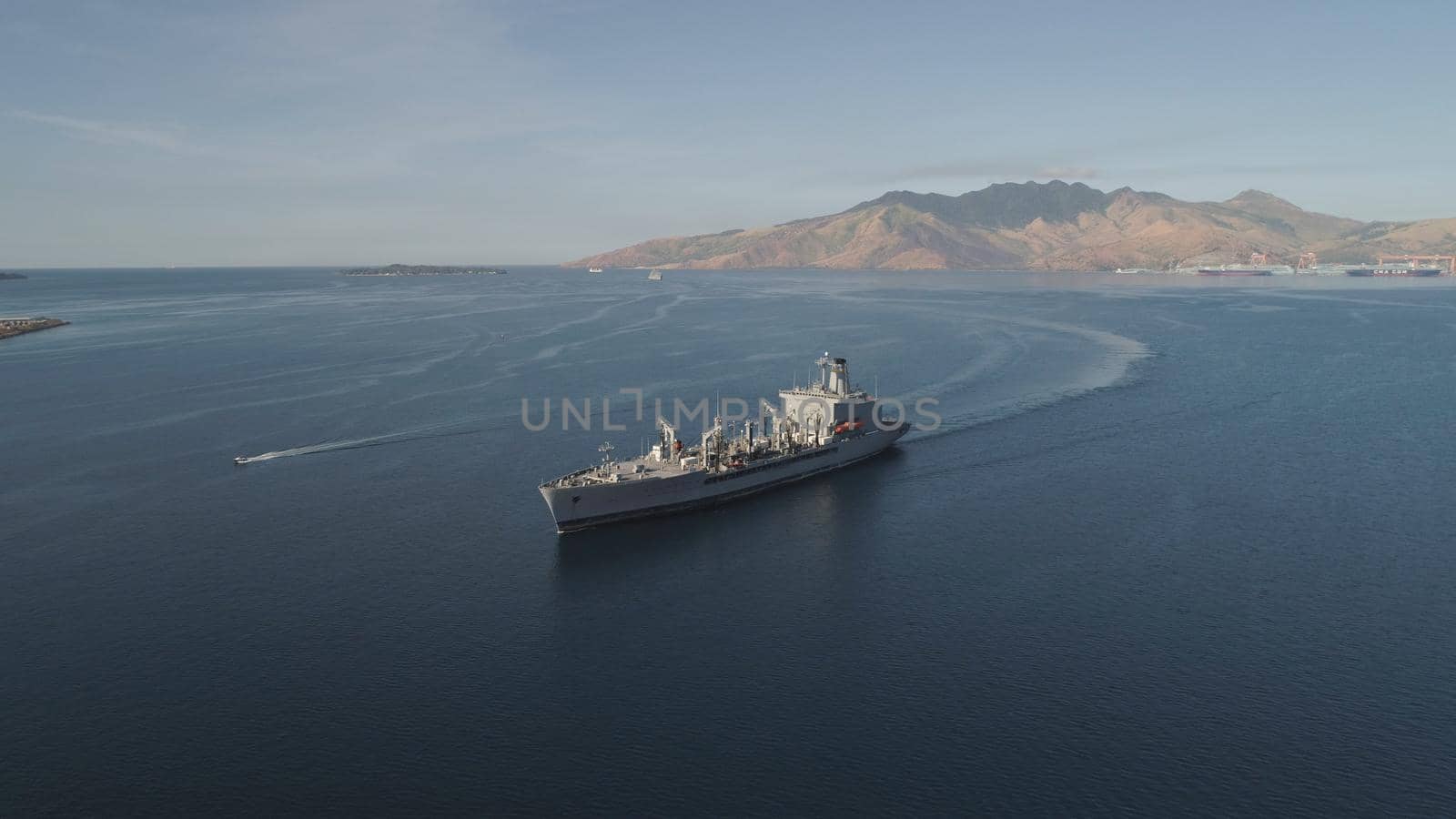 Aerial view: Cargo, Reefer ship in the sea bay. Subic Bay, Philippines, Luzon. Cargo ship in the harbor, against the backdrop of the mountains.